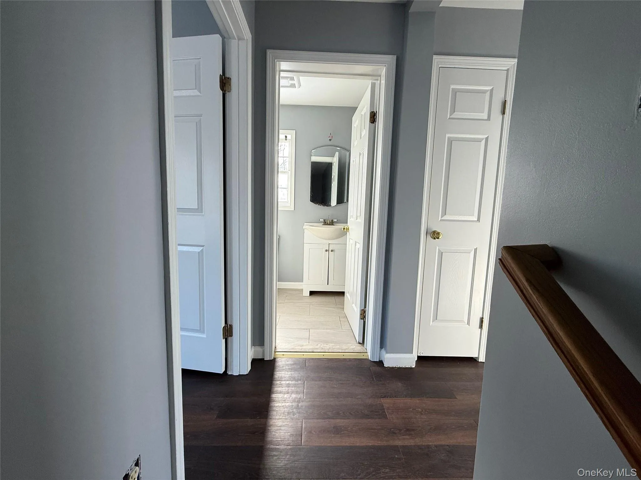 Corridor featuring dark wood-style flooring and baseboards Corridor featuring dark wood-style flooring and baseboards