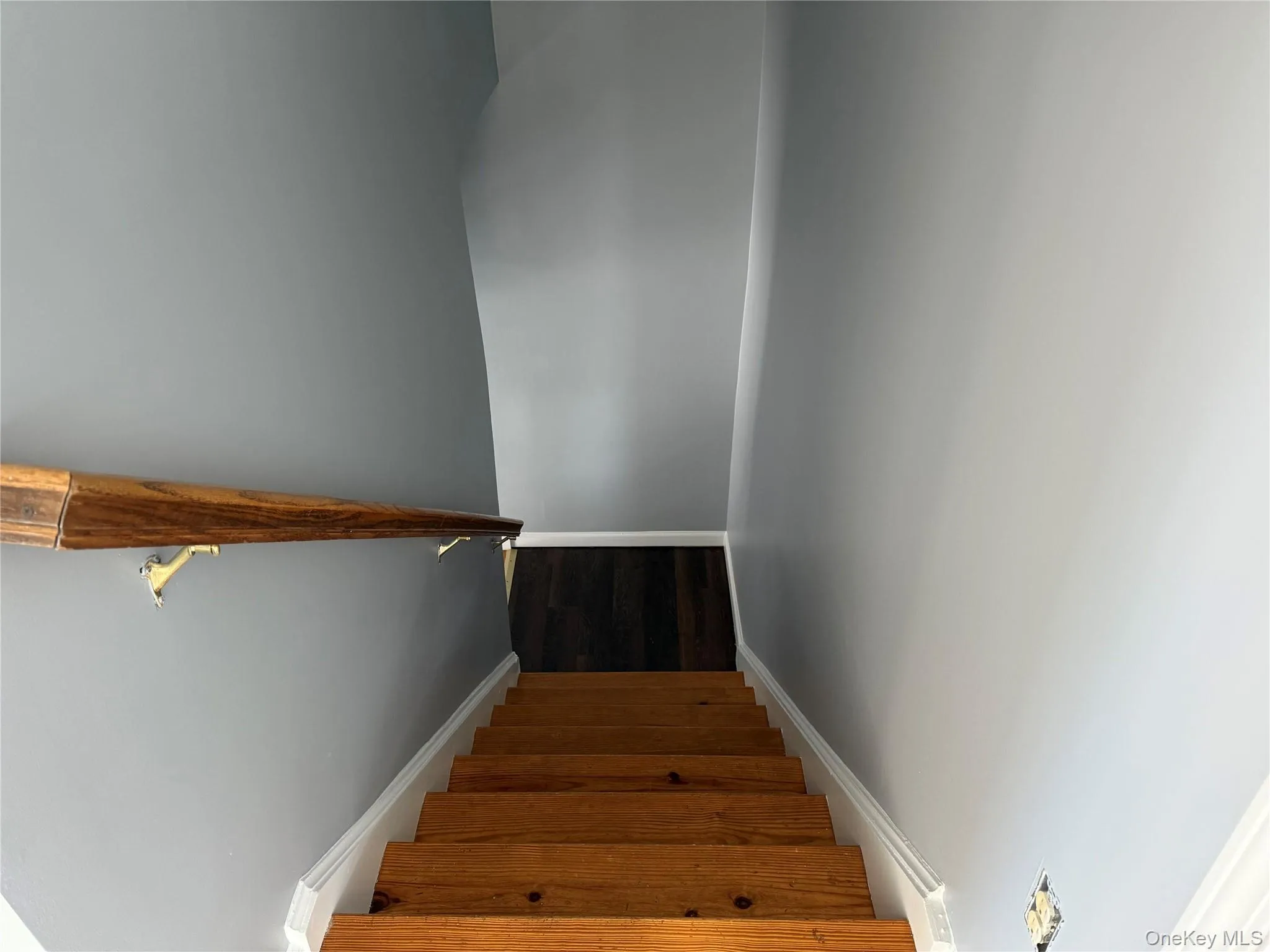 Stairs featuring wood finished floors Stairs featuring wood finished floors