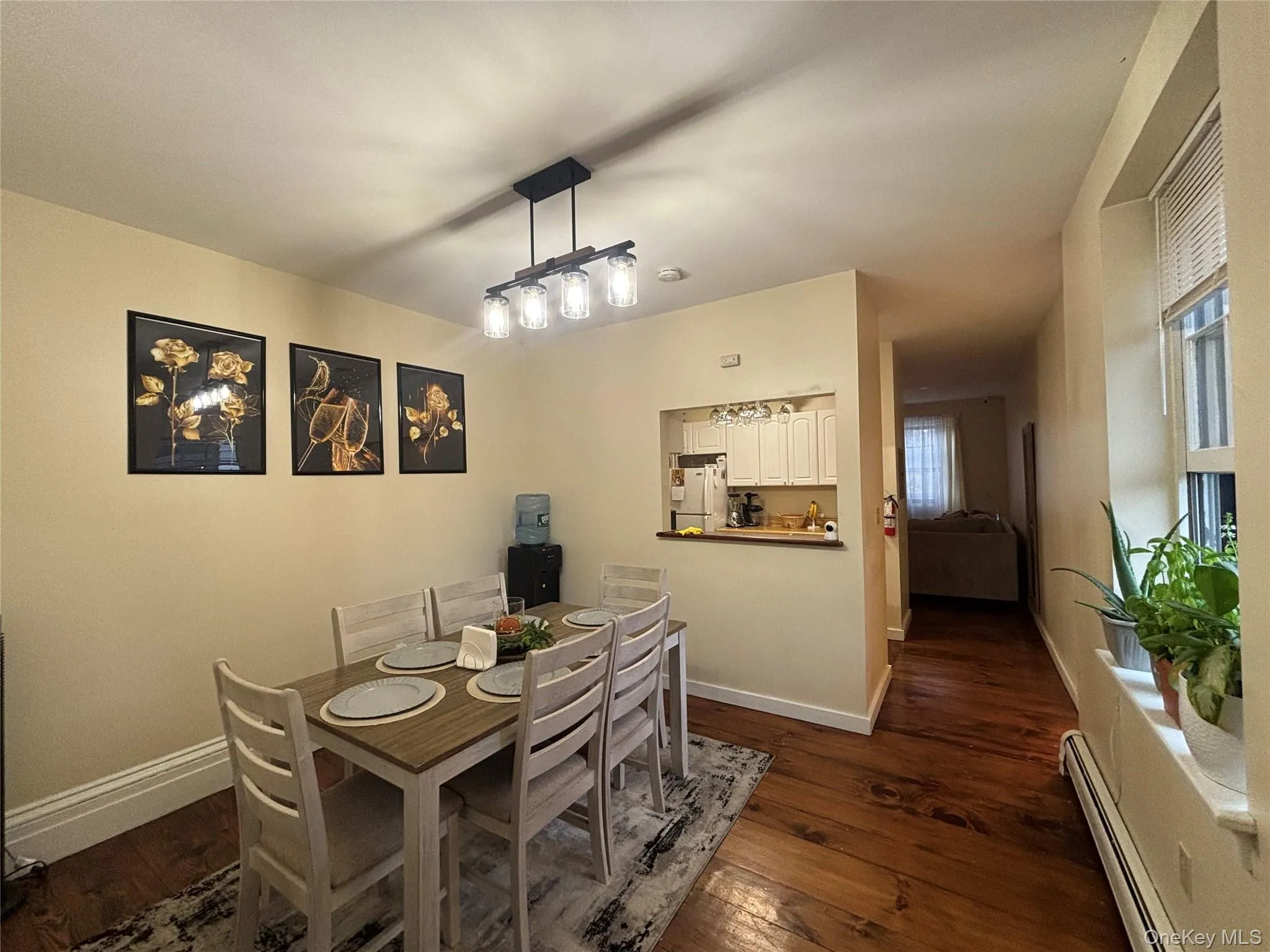 Dining area with baseboard heating and dark wood-style flooring Dining area with baseboard heating and dark wood-style flooring
