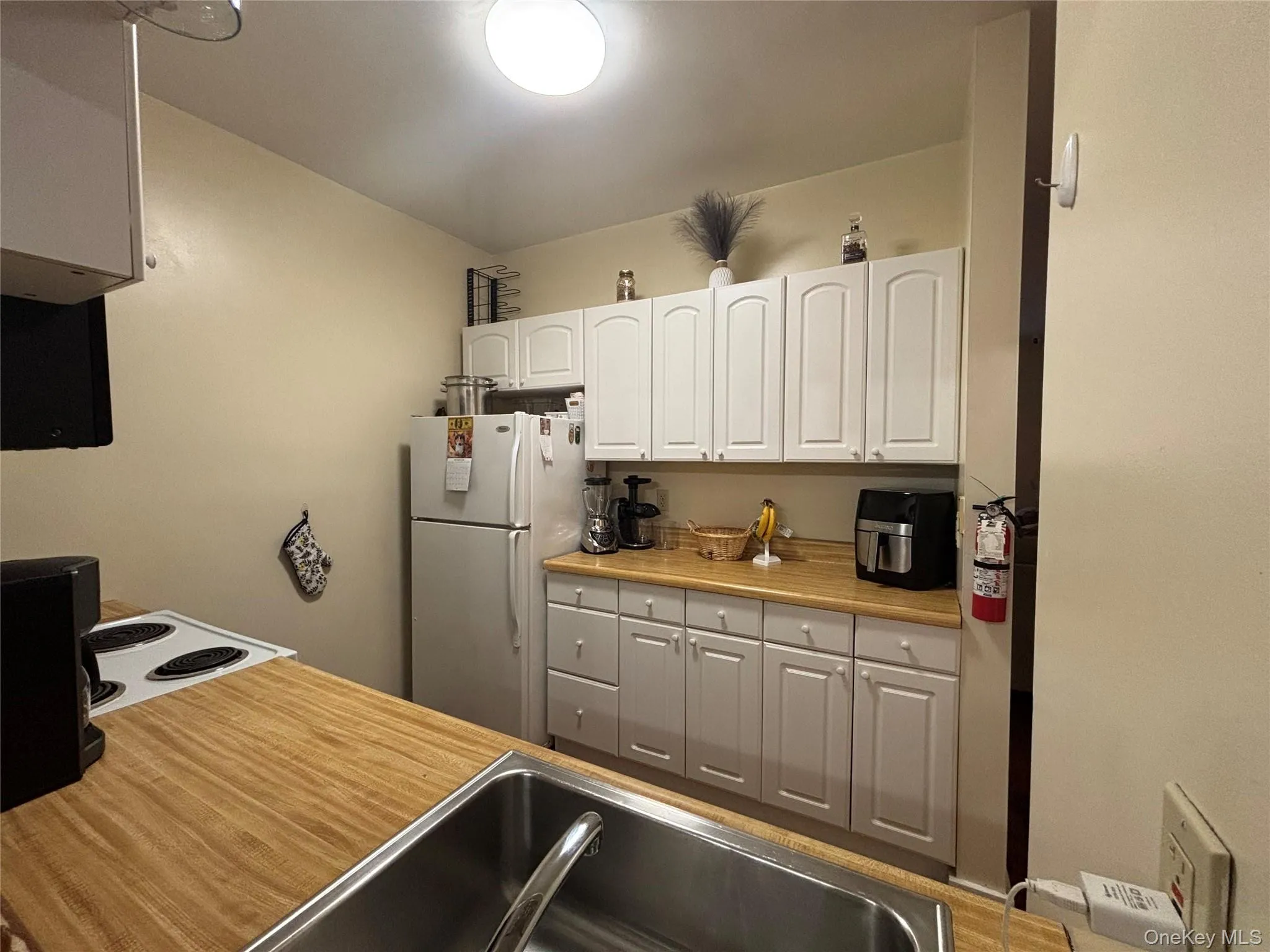 Kitchen featuring white appliances and white cabinetry Kitchen featuring white appliances and white cabinetry