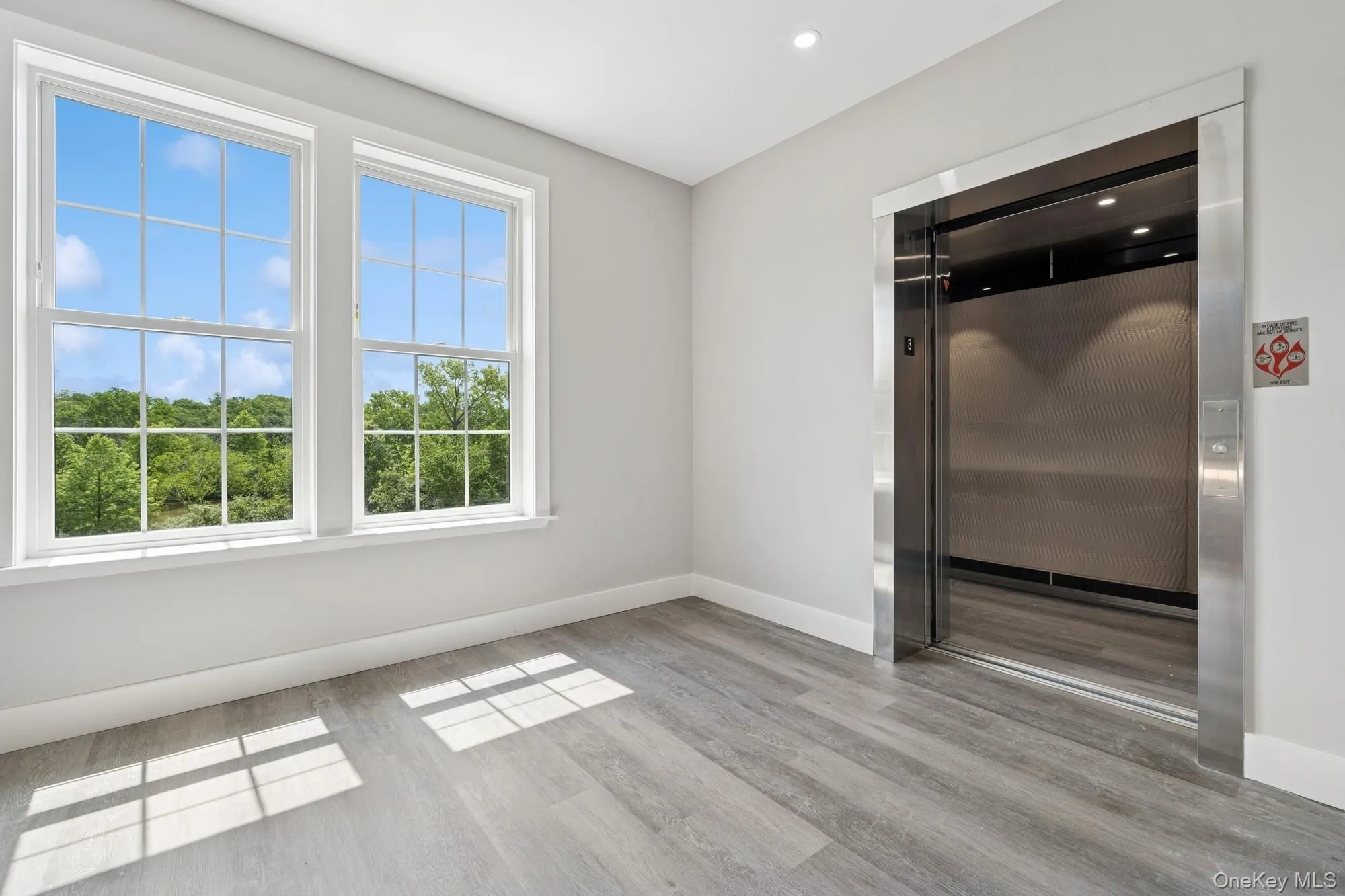 Unfurnished room with elevator and light wood-style floors Unfurnished room with elevator and light wood-style floors