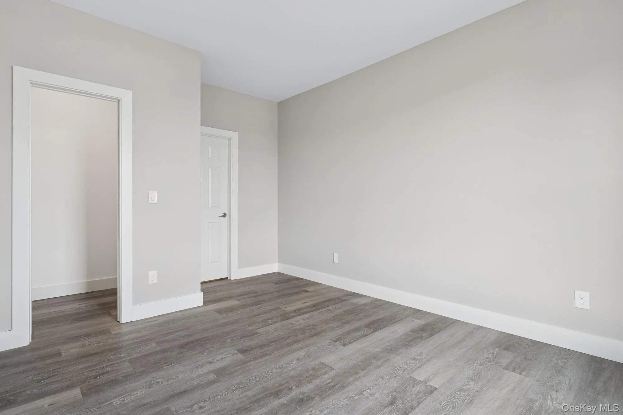 Unfurnished bedroom with dark wood-style floors Unfurnished bedroom with dark wood-style floors