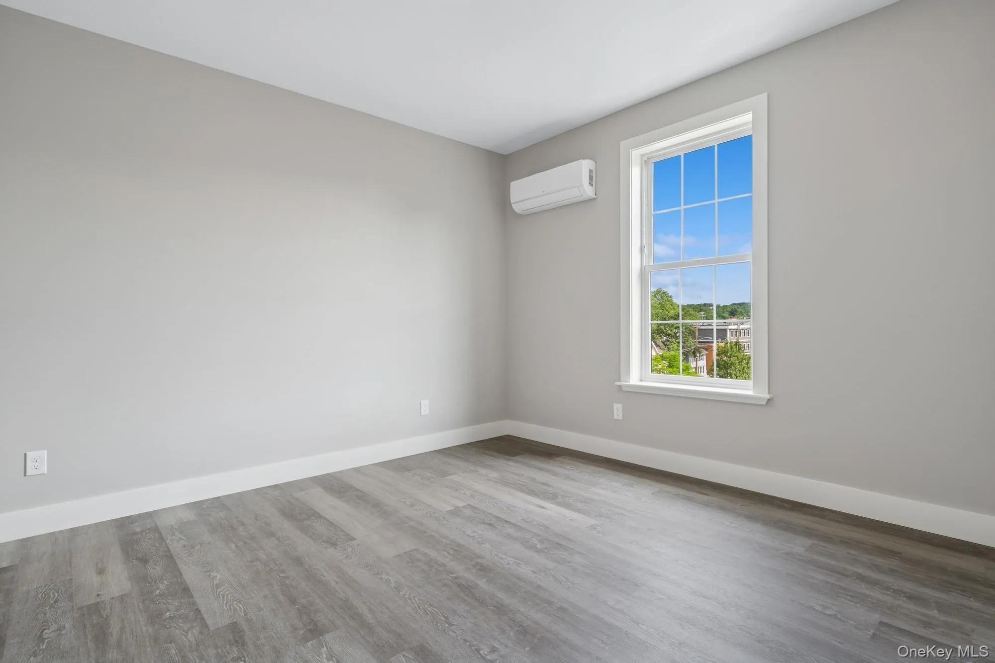 Spare room featuring wood finished floors and a wall mounted air conditioner Spare room featuring wood finished floors and a wall mounted air conditioner