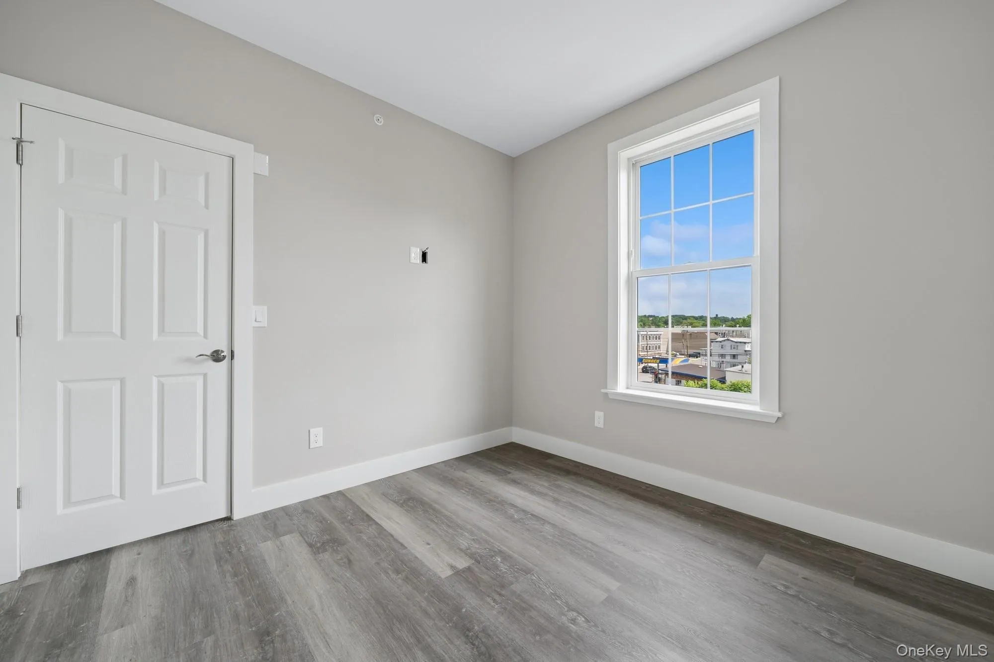 Spare room with wood finished floors and baseboards Spare room with wood finished floors and baseboards