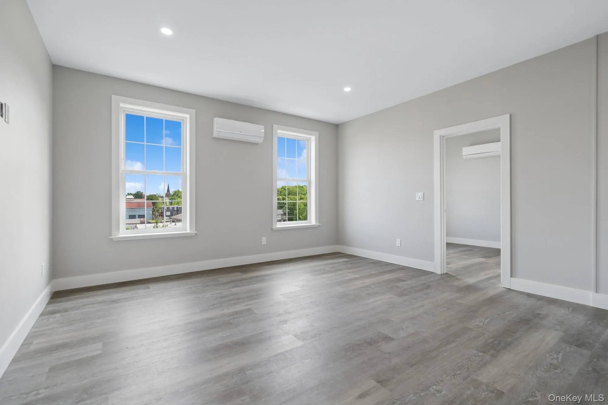 Unfurnished room featuring light wood finished floors, a wall mounted AC, and recessed lighting Unfurnished room featuring light wood finished floors, a wall mounted AC, and recessed lighting