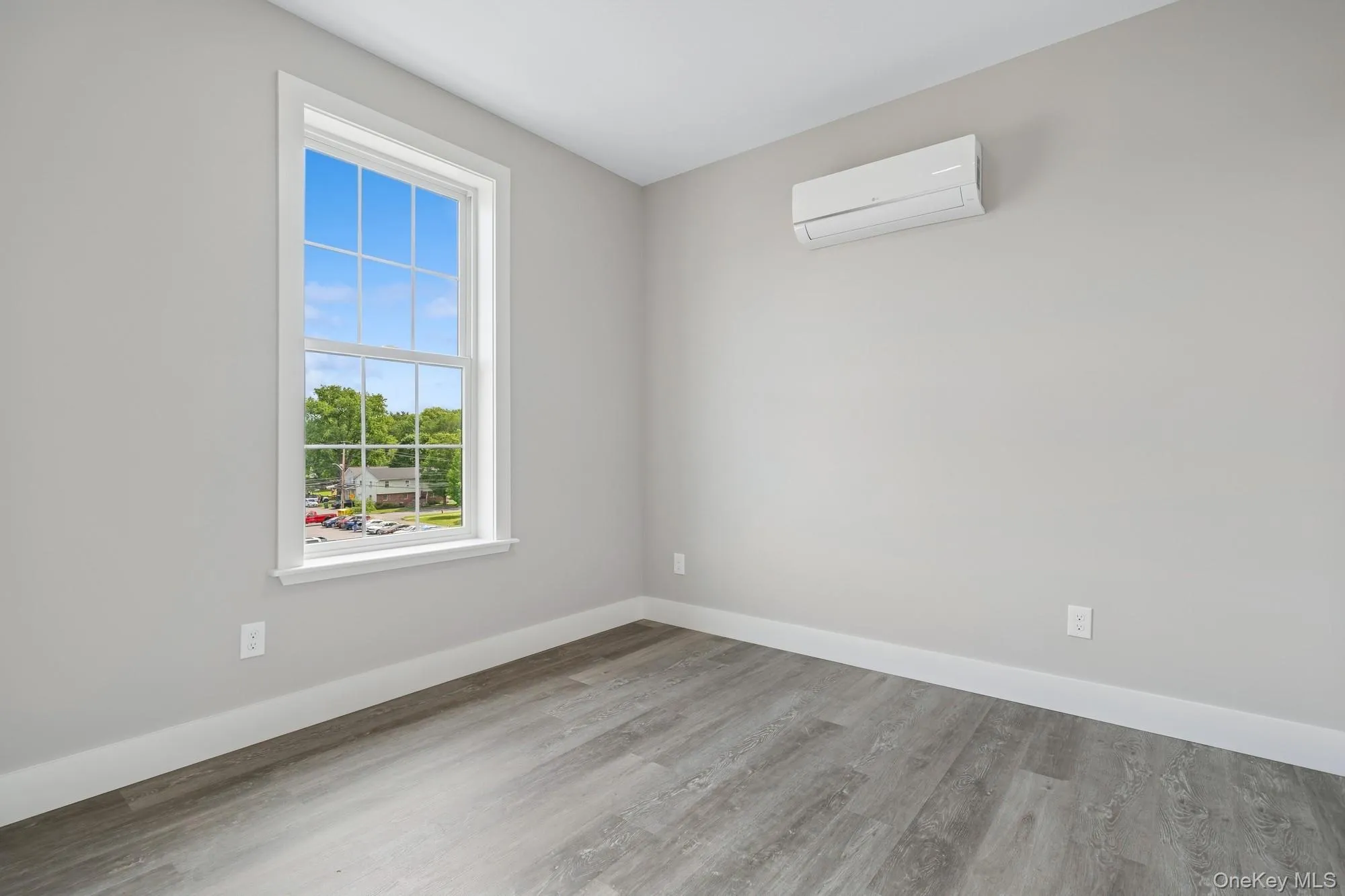Empty room featuring light wood-style floors and a wall unit AC Empty room featuring light wood-style floors and a wall unit AC