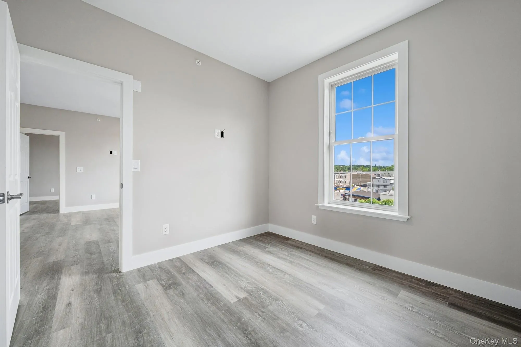 Unfurnished room with baseboards and light wood finished floors Unfurnished room with baseboards and light wood finished floors