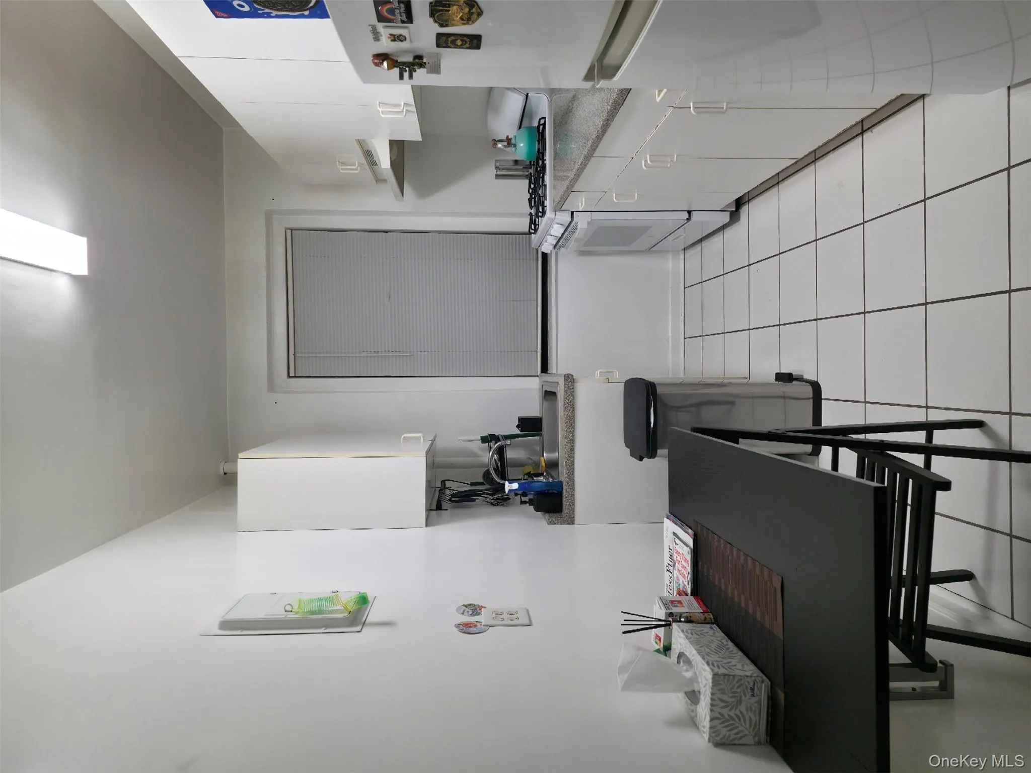 Kitchen featuring white cabinetry, stove, refrigerator, light tile patterned floors, and light countertops Kitchen featuring white cabinetry, stove, refrigerator, light tile patterned floors, and light countertops