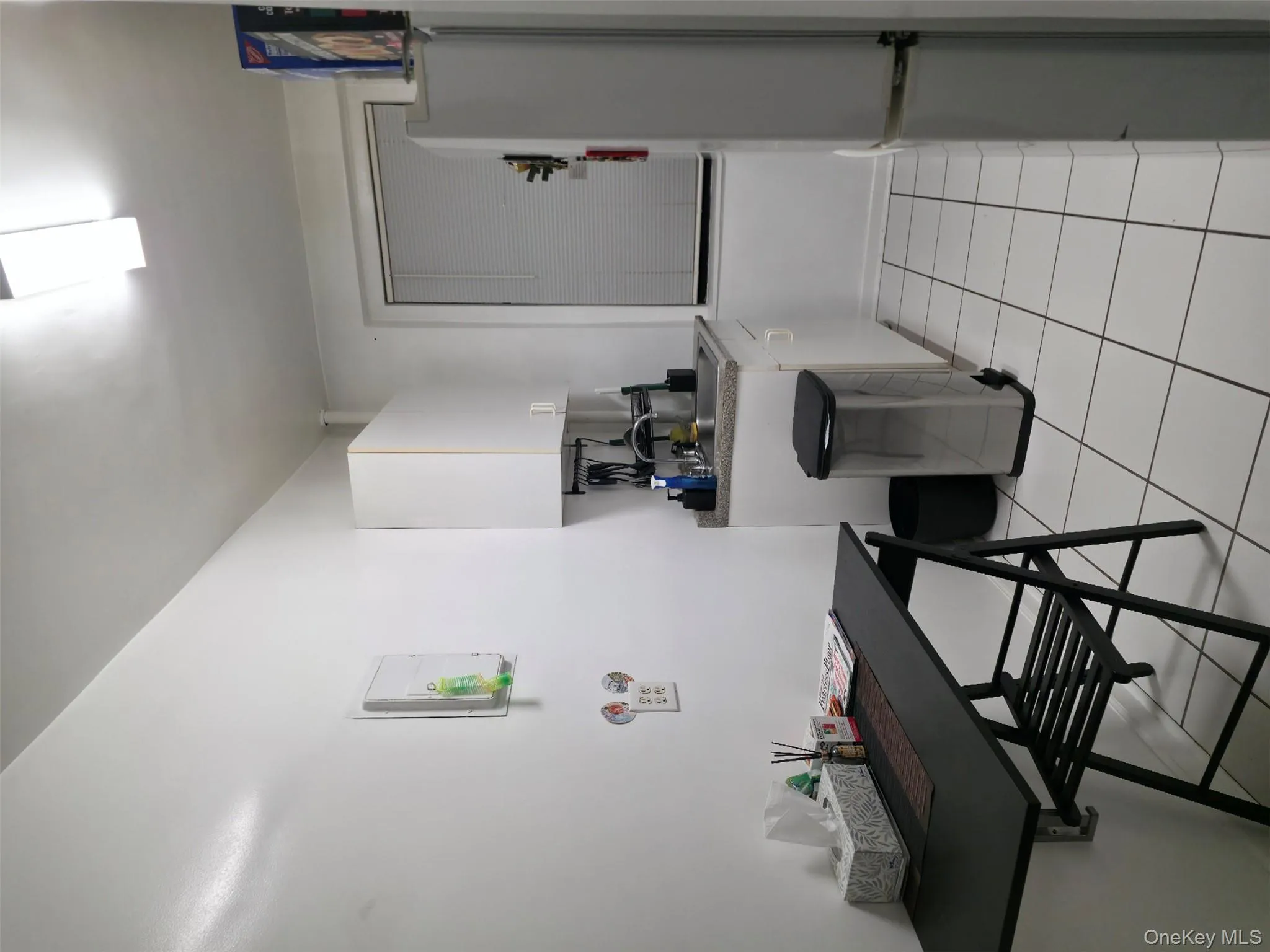 Kitchen featuring white cabinets, fridge, and light tile patterned flooring Kitchen featuring white cabinets, fridge, and light tile patterned flooring