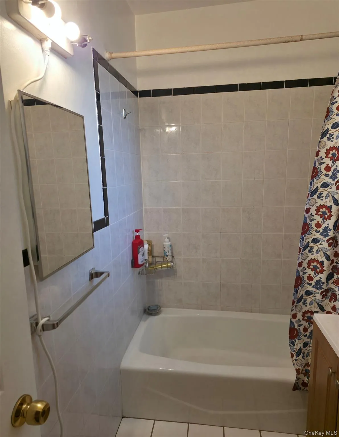 Full bathroom featuring shower / bathtub combination with curtain, tile patterned flooring, and vanity Full bathroom featuring shower / bathtub combination with curtain, tile patterned flooring, and vanity