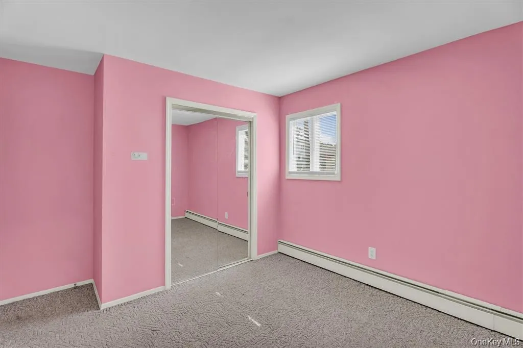 Spare room with a baseboard heating unit and carpet flooring Spare room with a baseboard heating unit and carpet flooring