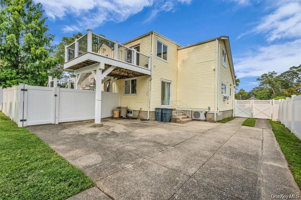Rear view of property featuring a gate, a fenced backyard, a patio area, and a wooden deck Rear view of property featuring a gate, a fenced backyard, a patio area, and a wooden deck