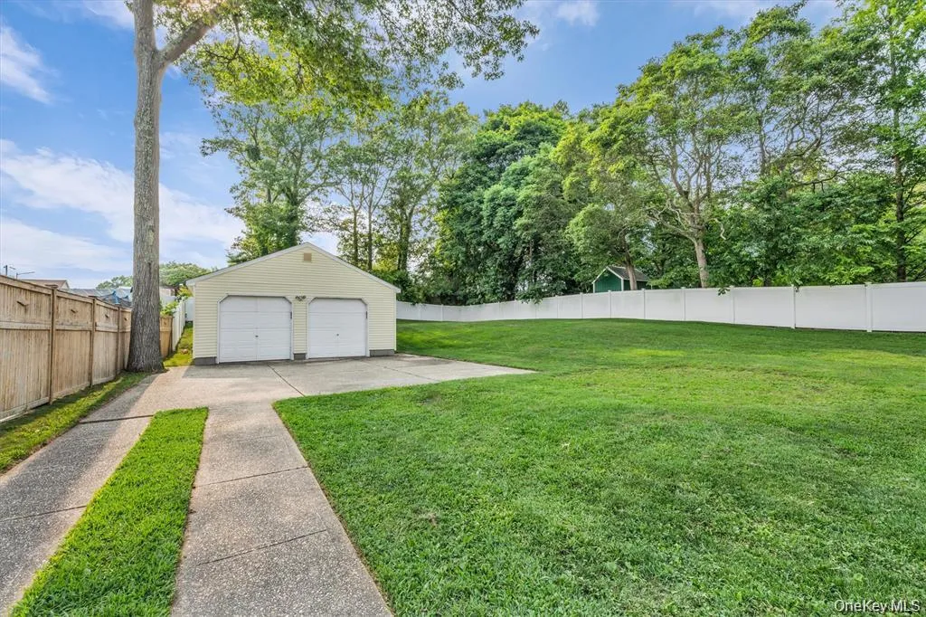 Fenced backyard with an outdoor structure and a detached garage Fenced backyard with an outdoor structure and a detached garage