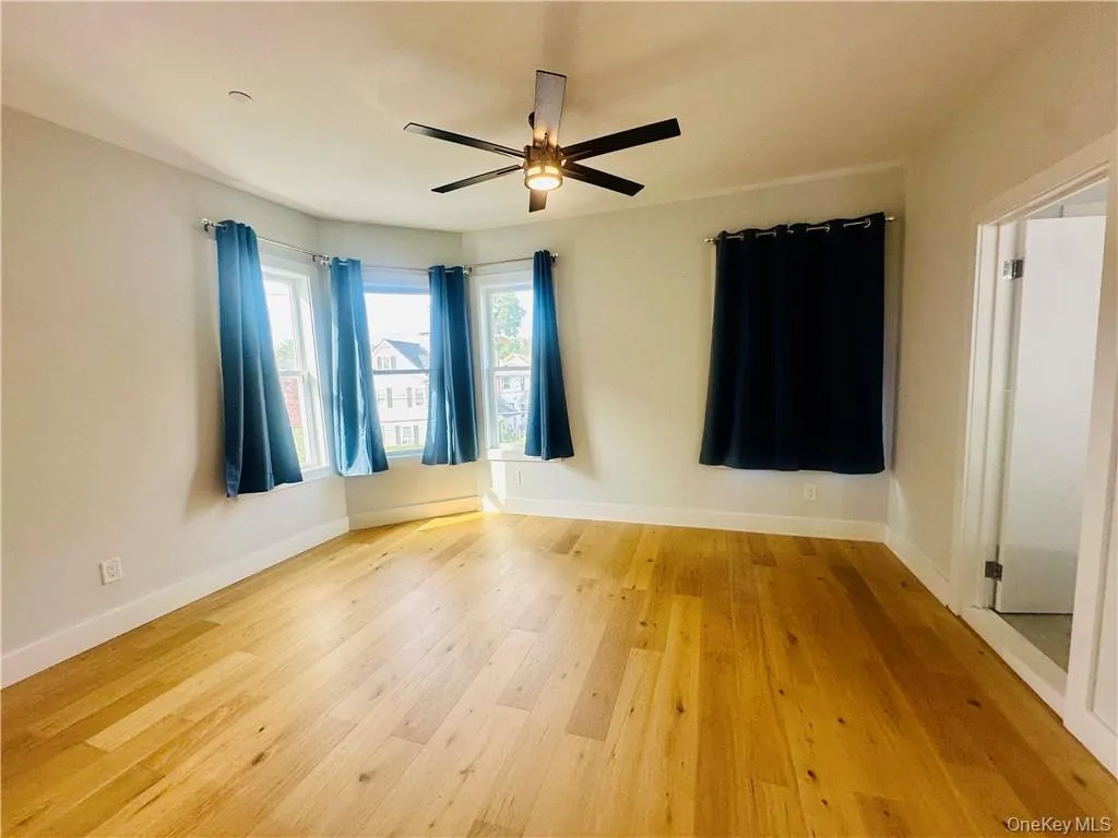 Unfurnished room with hardwood / wood-style floors and ceiling fan Unfurnished room with hardwood / wood-style floors and ceiling fan