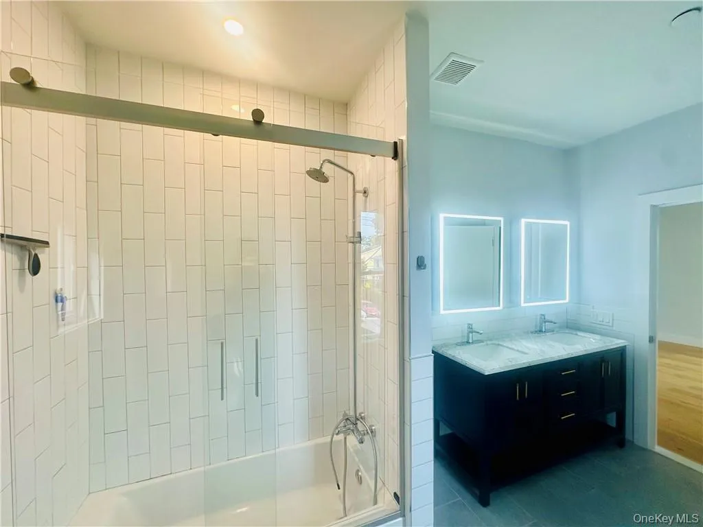 Bathroom with bath / shower combo with glass door and vanity Bathroom with bath / shower combo with glass door and vanity