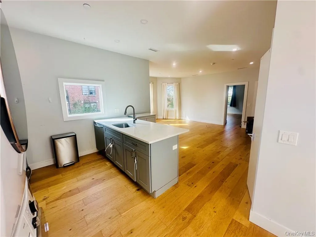 Kitchen featuring light hardwood / wood-style flooring, sink, kitchen peninsula, and gray cabinetry Kitchen featuring light hardwood / wood-style flooring, sink, kitchen peninsula, and gray cabinetry