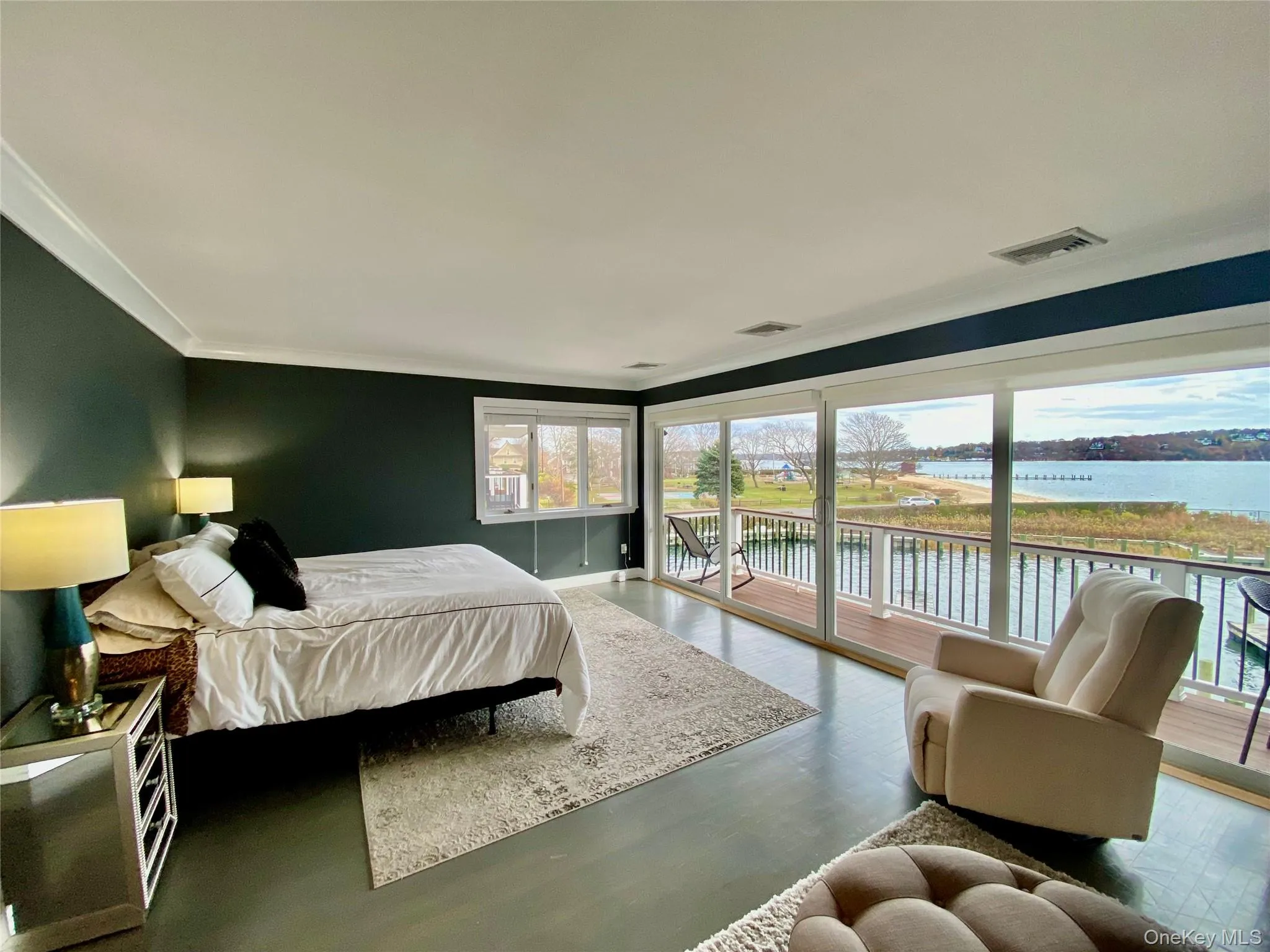Bedroom with access to outside, a water view, wood finished floors, and ornamental molding Bedroom with access to outside, a water view, wood finished floors, and ornamental molding