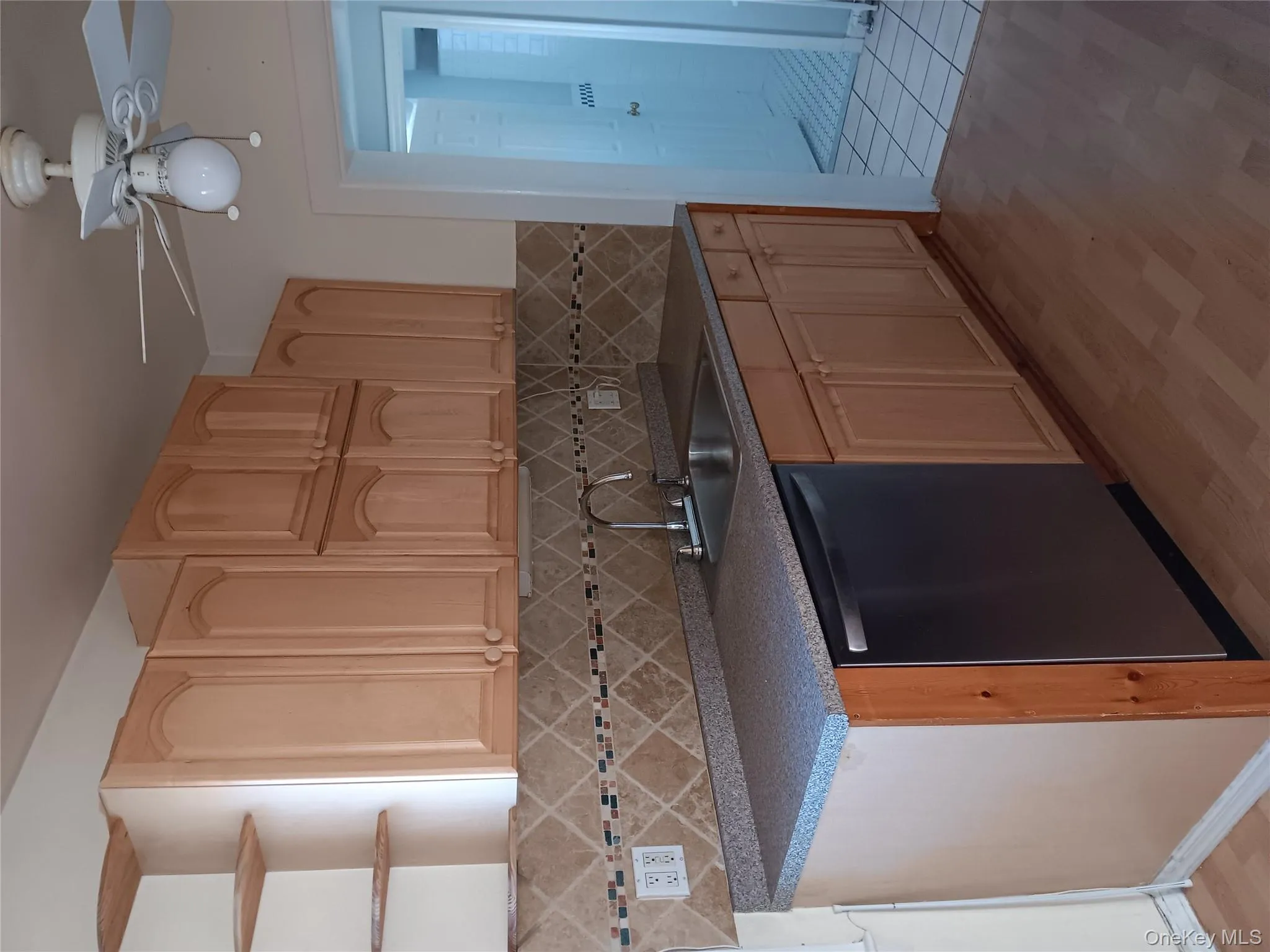 Kitchen with light brown cabinets, ceiling fan, and light wood-type flooring Kitchen with light brown cabinets, ceiling fan, and light wood-type flooring