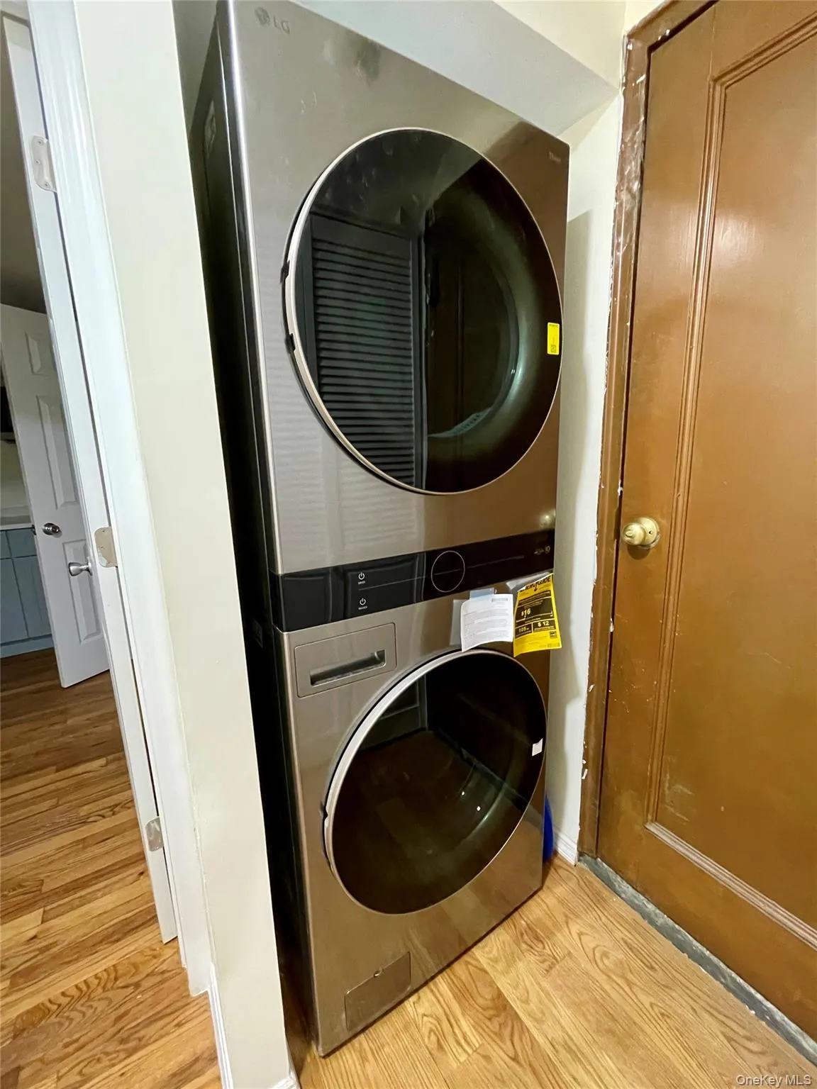 Washroom with light wood finished floors and estacked washer and dryer Washroom with light wood finished floors and estacked washer and dryer