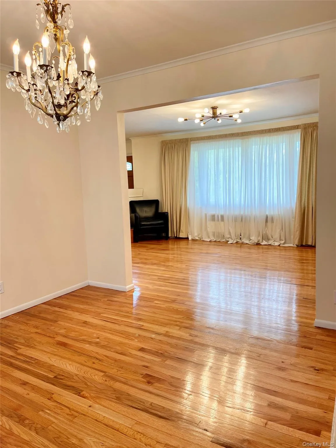 Unfurnished dining area featuring a chandelier, light wood-style floors, and crown molding Unfurnished dining area featuring a chandelier, light wood-style floors, and crown molding