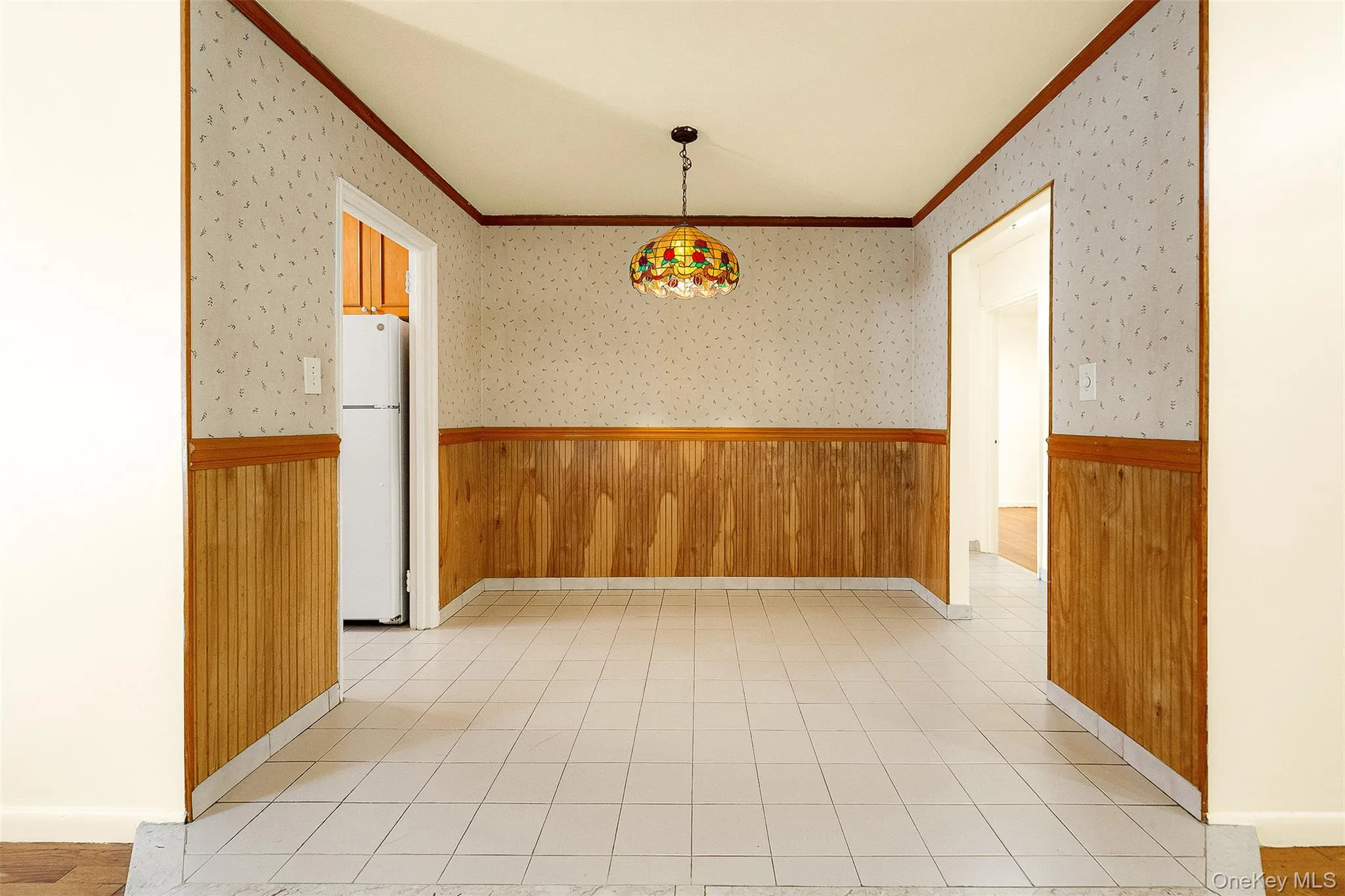 Unfurnished dining area featuring wood walls, a wainscoted wall, and wallpapered walls Unfurnished dining area featuring wood walls, a wainscoted wall, and wallpapered walls