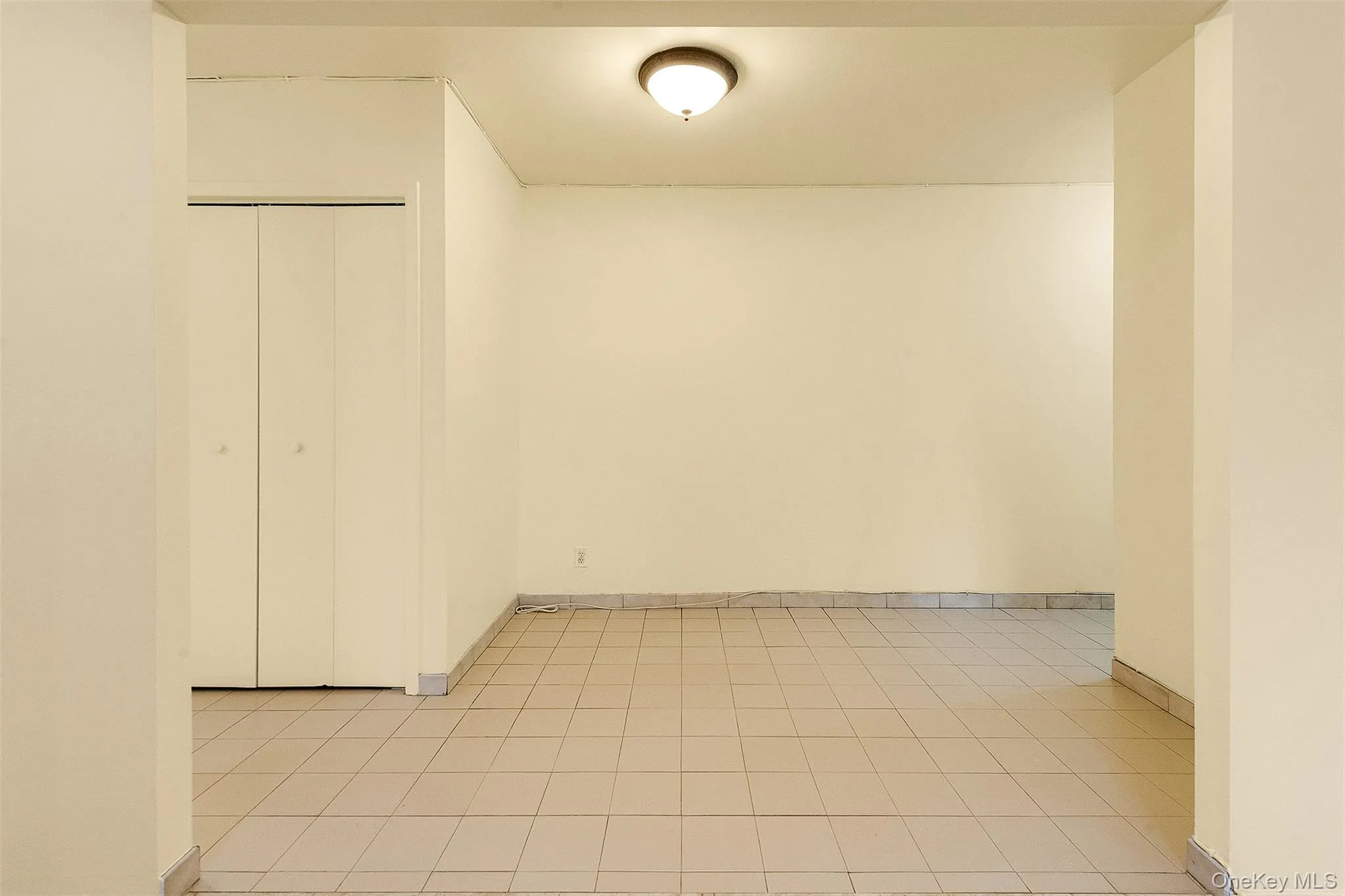 Spare room with baseboards and light tile patterned flooring Spare room with baseboards and light tile patterned flooring