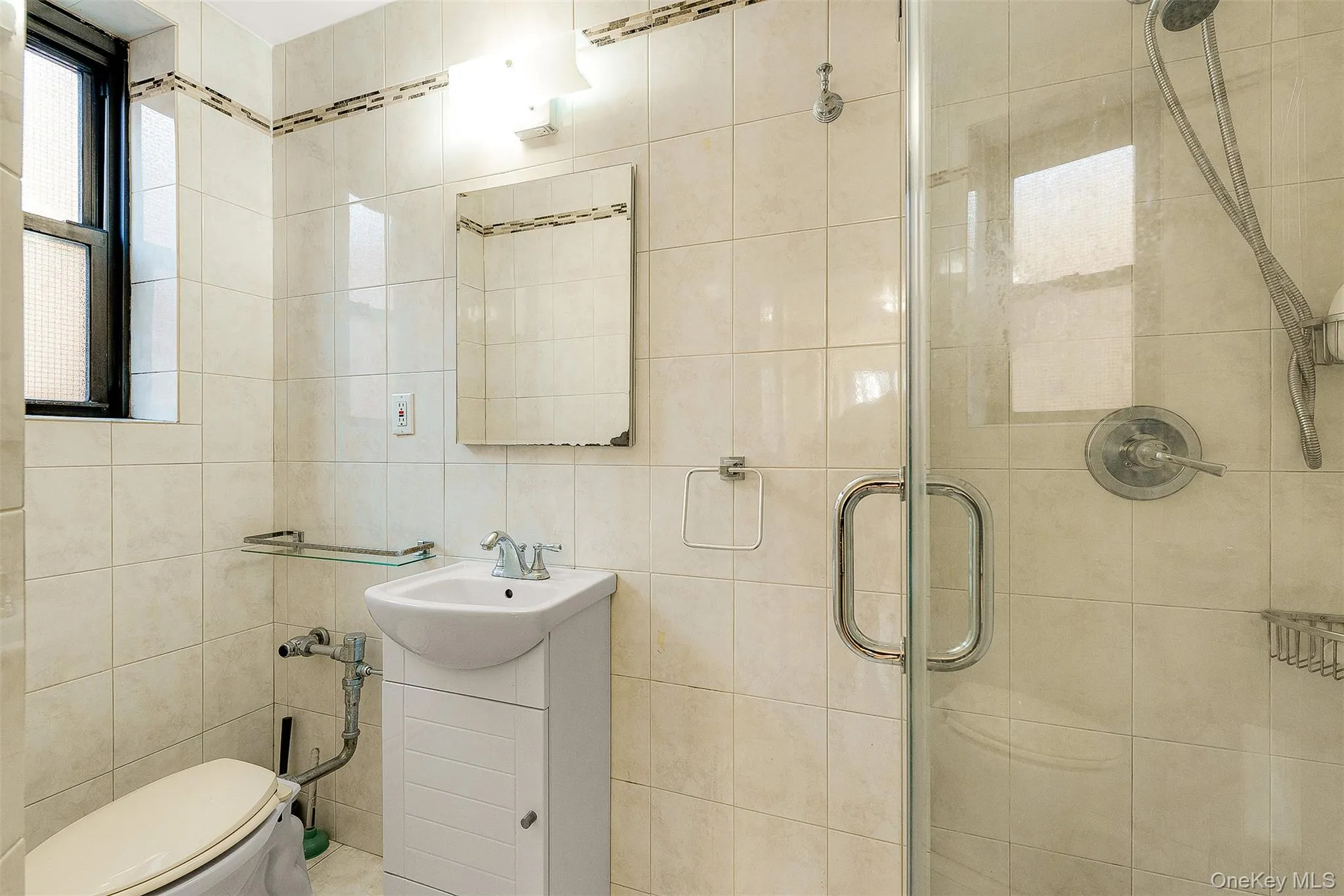 Full bath with vanity, a shower stall, and tile walls Full bath with vanity, a shower stall, and tile walls