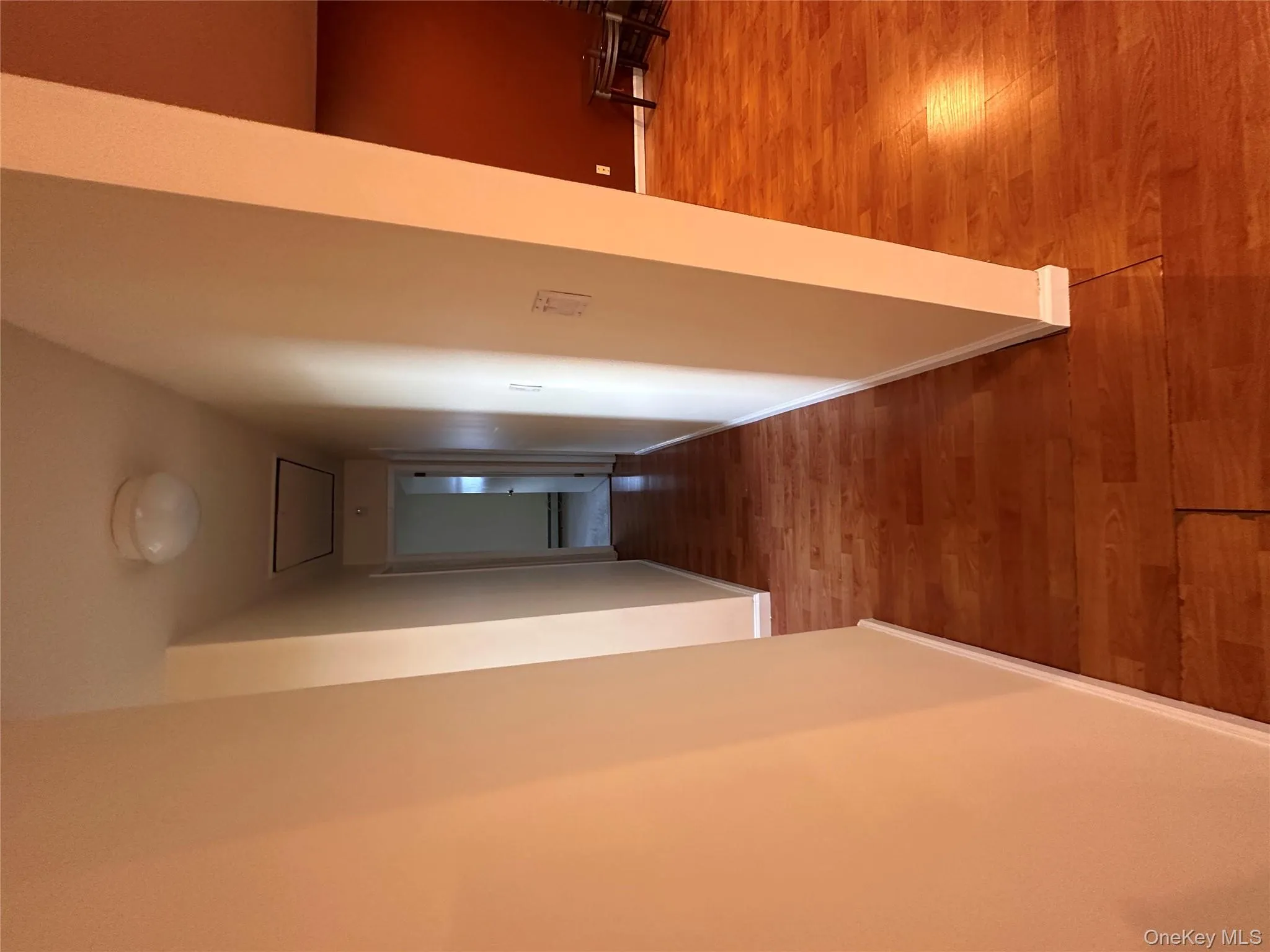 Hall featuring light wood-style floors and attic access Hall featuring light wood-style floors and attic access