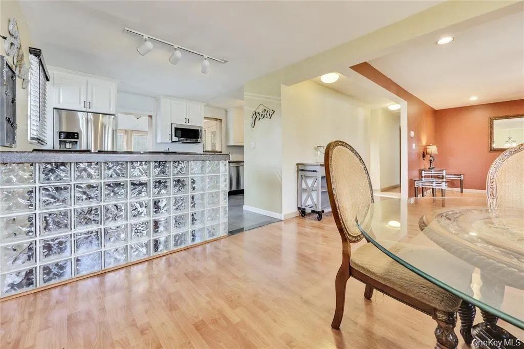 Dining room with light wood finished floors and track lighting Dining room with light wood finished floors and track lighting