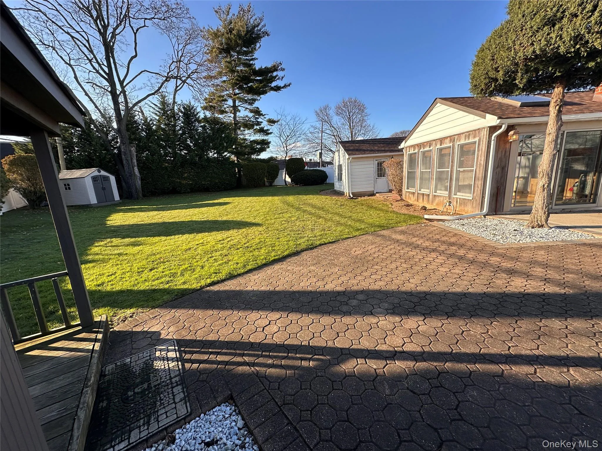 View of grassy yard with a storage unit and a sunroom View of grassy yard with a storage unit and a sunroom