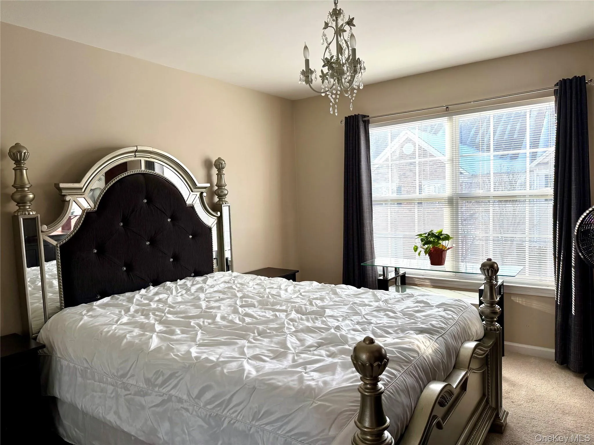 Carpeted bedroom with baseboards and a chandelier Carpeted bedroom with baseboards and a chandelier