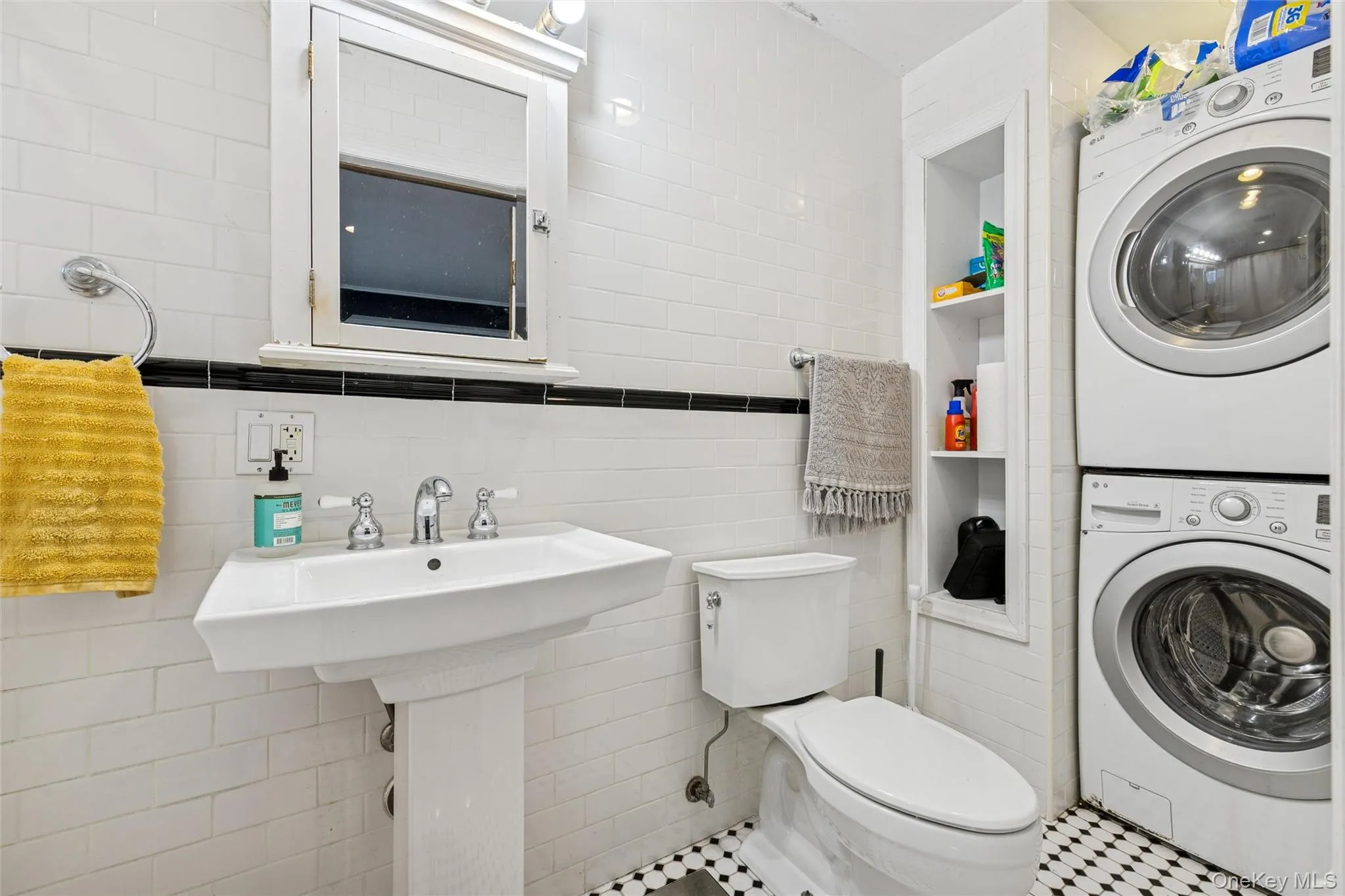 Bathroom with tile walls and stacked washer / dryer Bathroom with tile walls and stacked washer / dryer