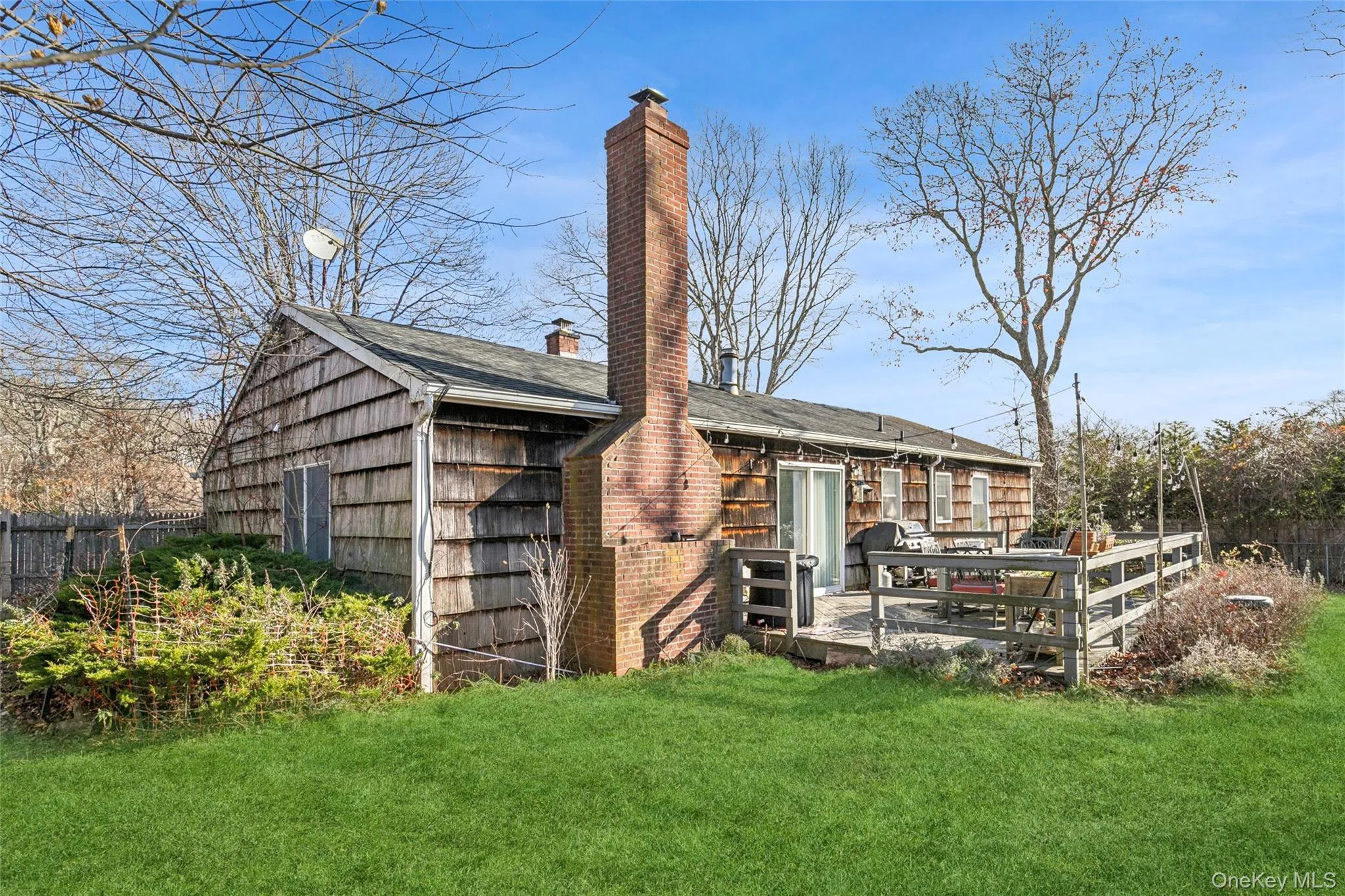 Back of house featuring a chimney and a wooden deck Back of house featuring a chimney and a wooden deck