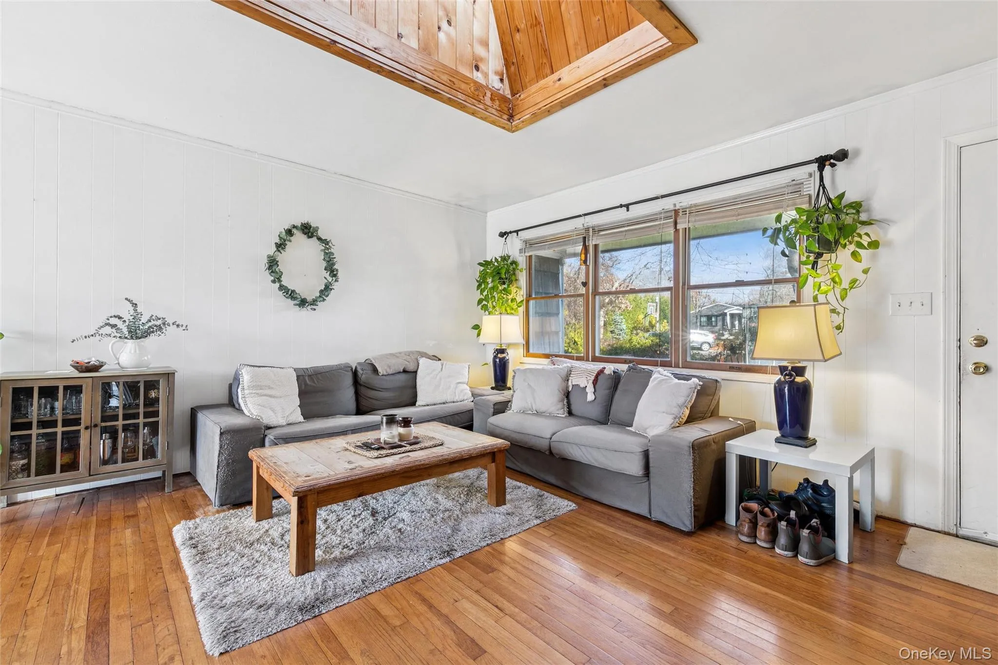 Living area featuring hardwood / wood-style floors and wooden walls Living area featuring hardwood / wood-style floors and wooden walls