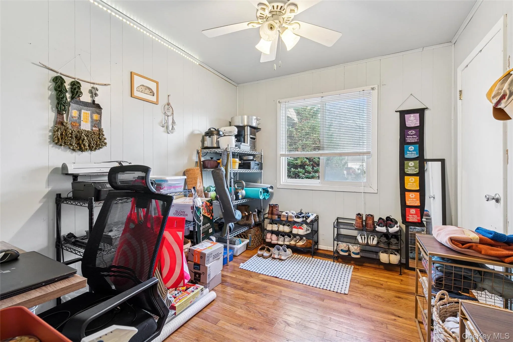 Office area with wood-type flooring, wood walls, and a ceiling fan Office area with wood-type flooring, wood walls, and a ceiling fan