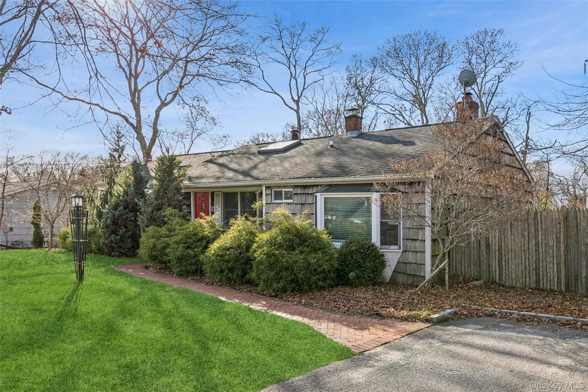 View of front facade featuring a shingled roof and a chimney View of front facade featuring a shingled roof and a chimney