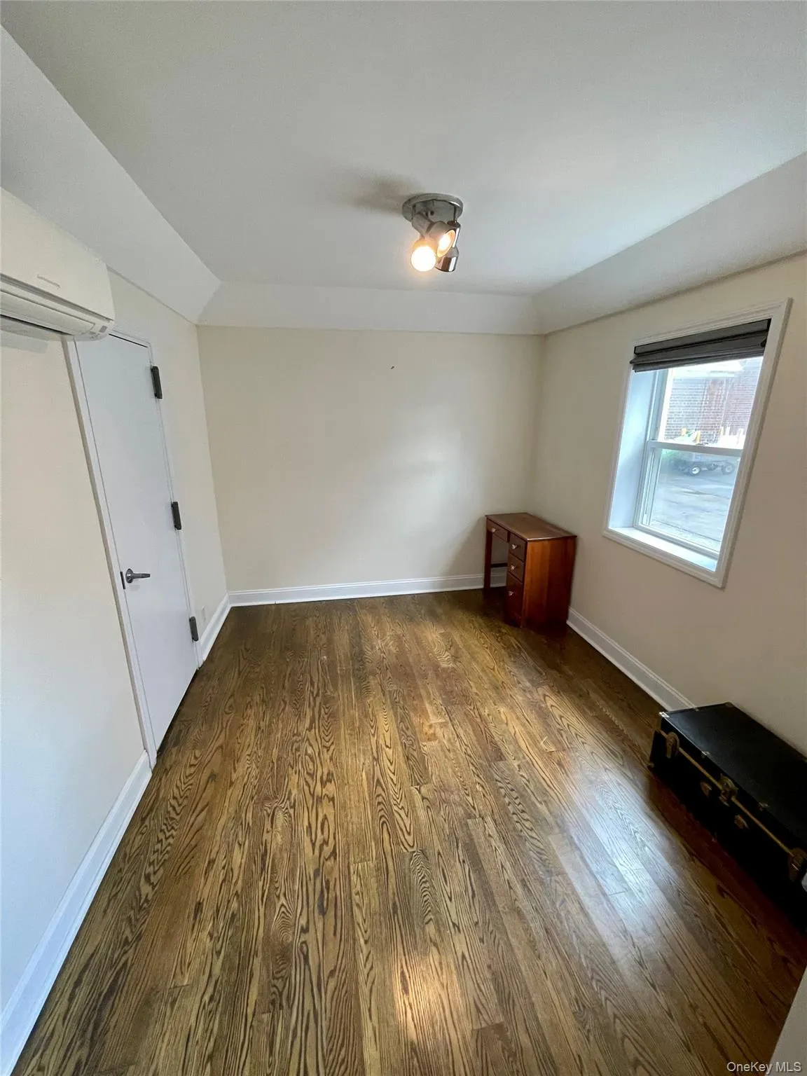 Spare room featuring dark wood finished floors and a wall unit AC Spare room featuring dark wood finished floors and a wall unit AC