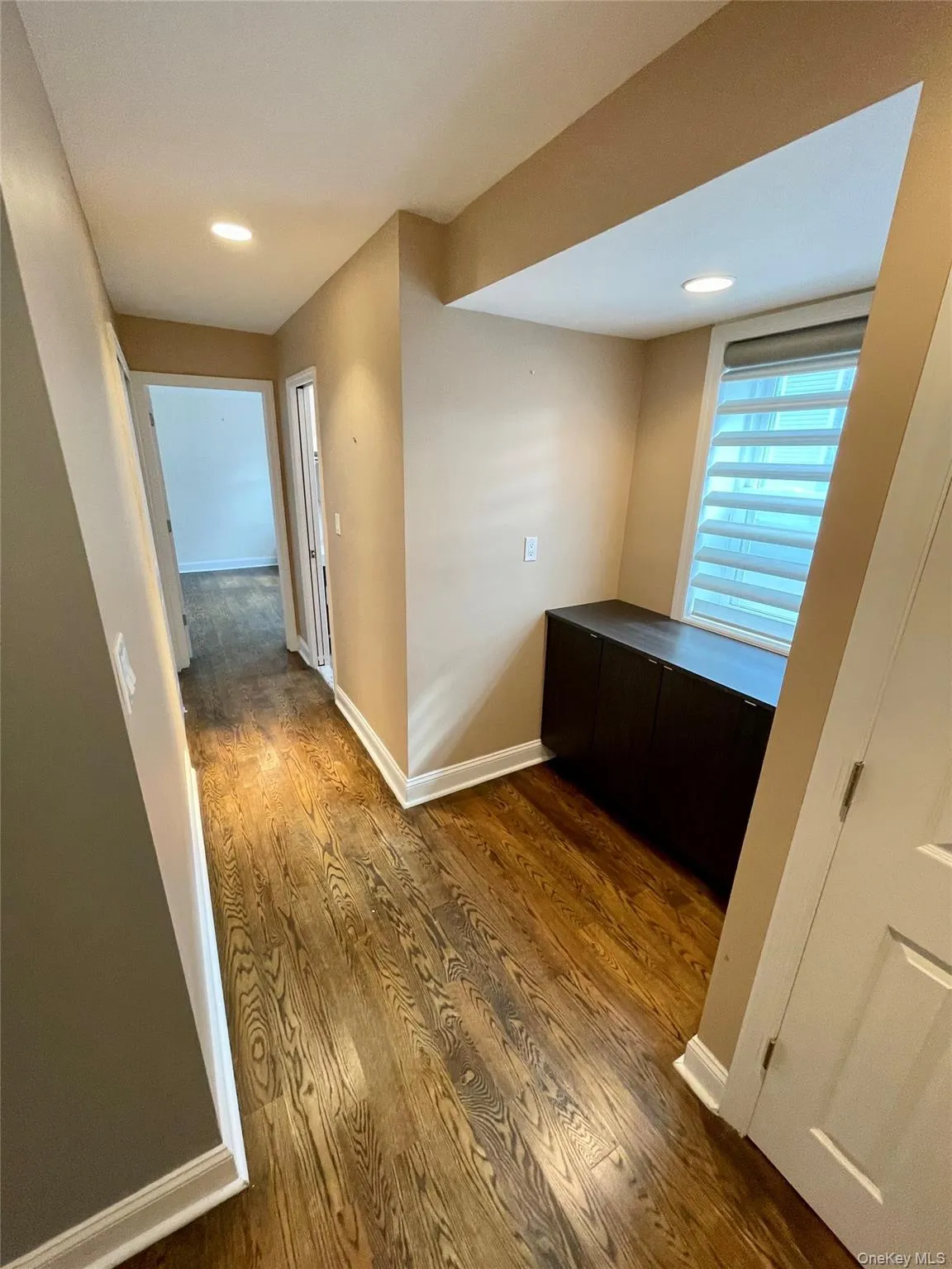Corridor with dark wood-type flooring and recessed lighting Corridor with dark wood-type flooring and recessed lighting