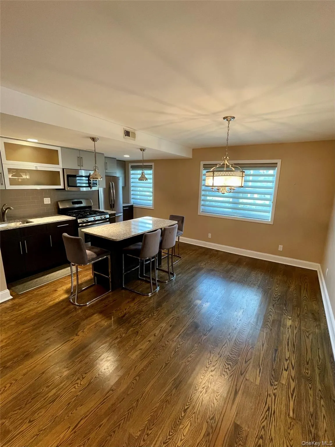 Dining room with baseboards and dark wood-style flooring Dining room with baseboards and dark wood-style flooring
