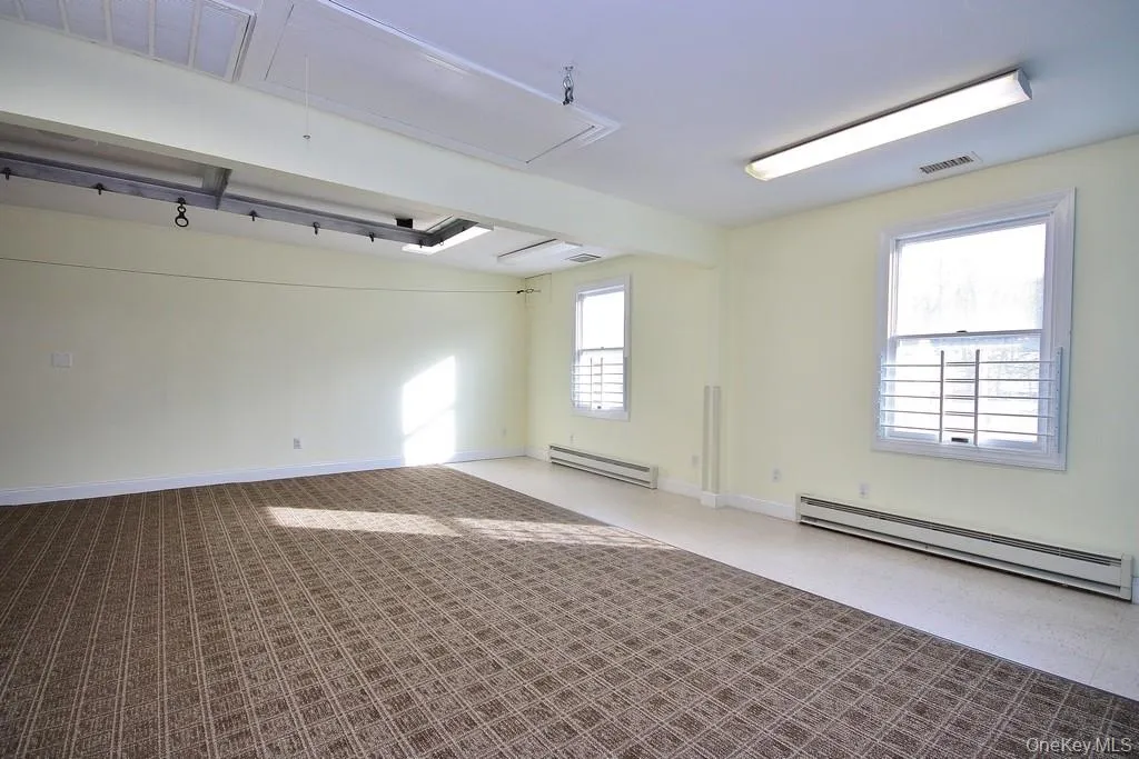 Spare room with attic access and a baseboard heating unit Spare room with attic access and a baseboard heating unit