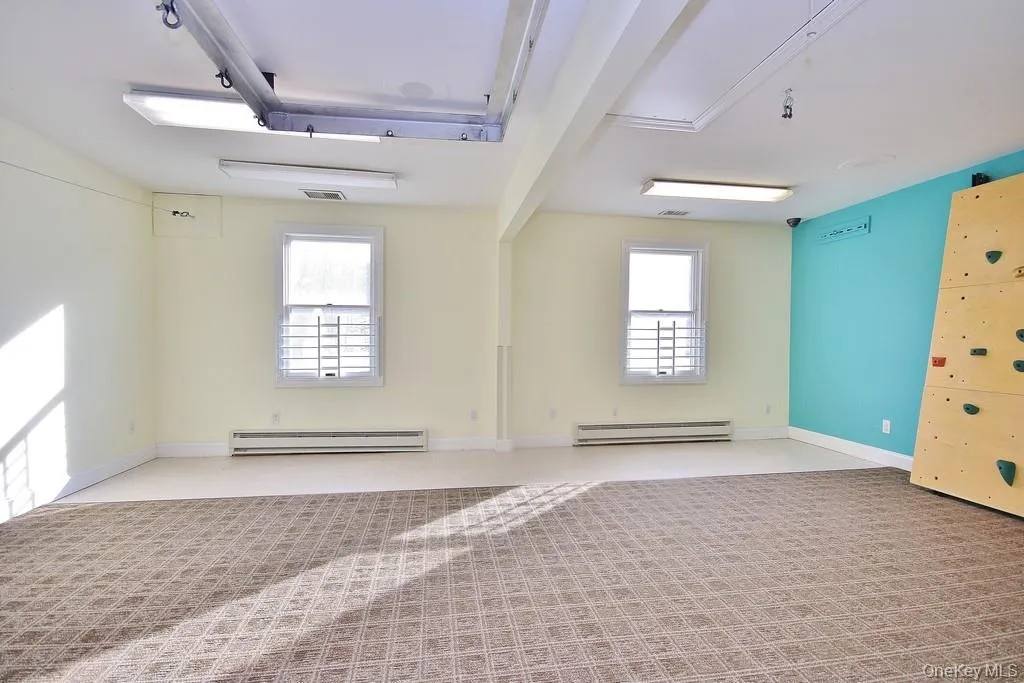 Unfurnished room with light colored carpet and a baseboard heating unit Unfurnished room with light colored carpet and a baseboard heating unit