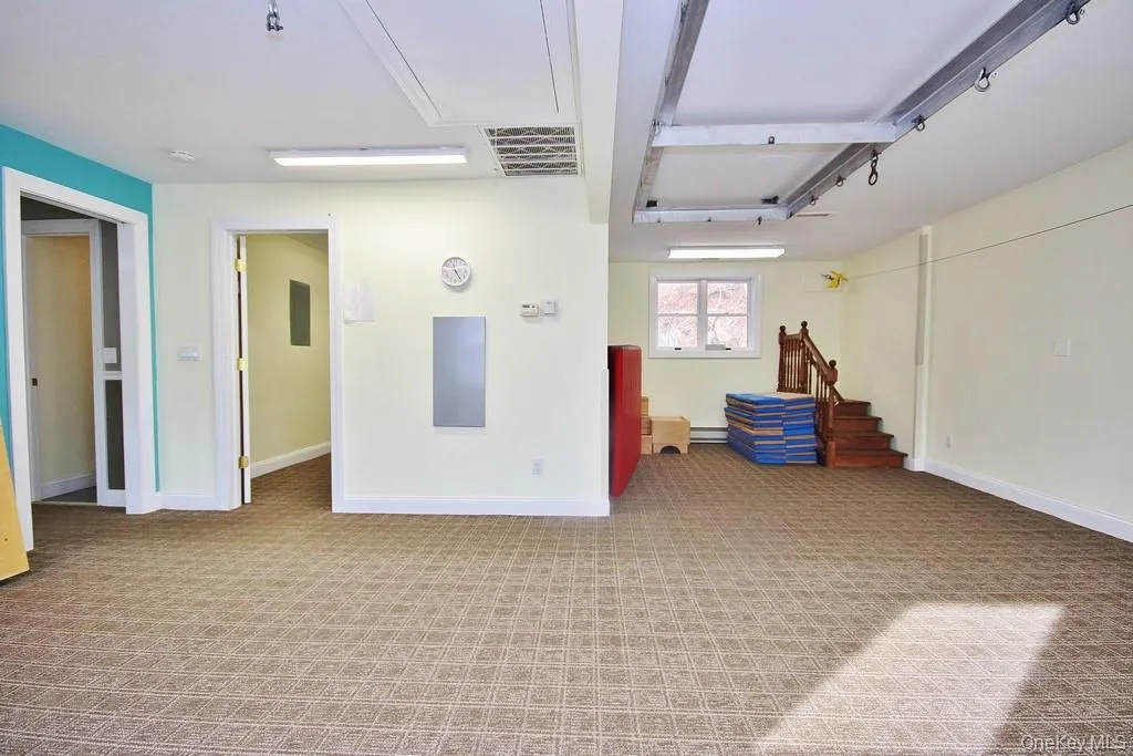 Spare room featuring light colored carpet and electric panel Spare room featuring light colored carpet and electric panel