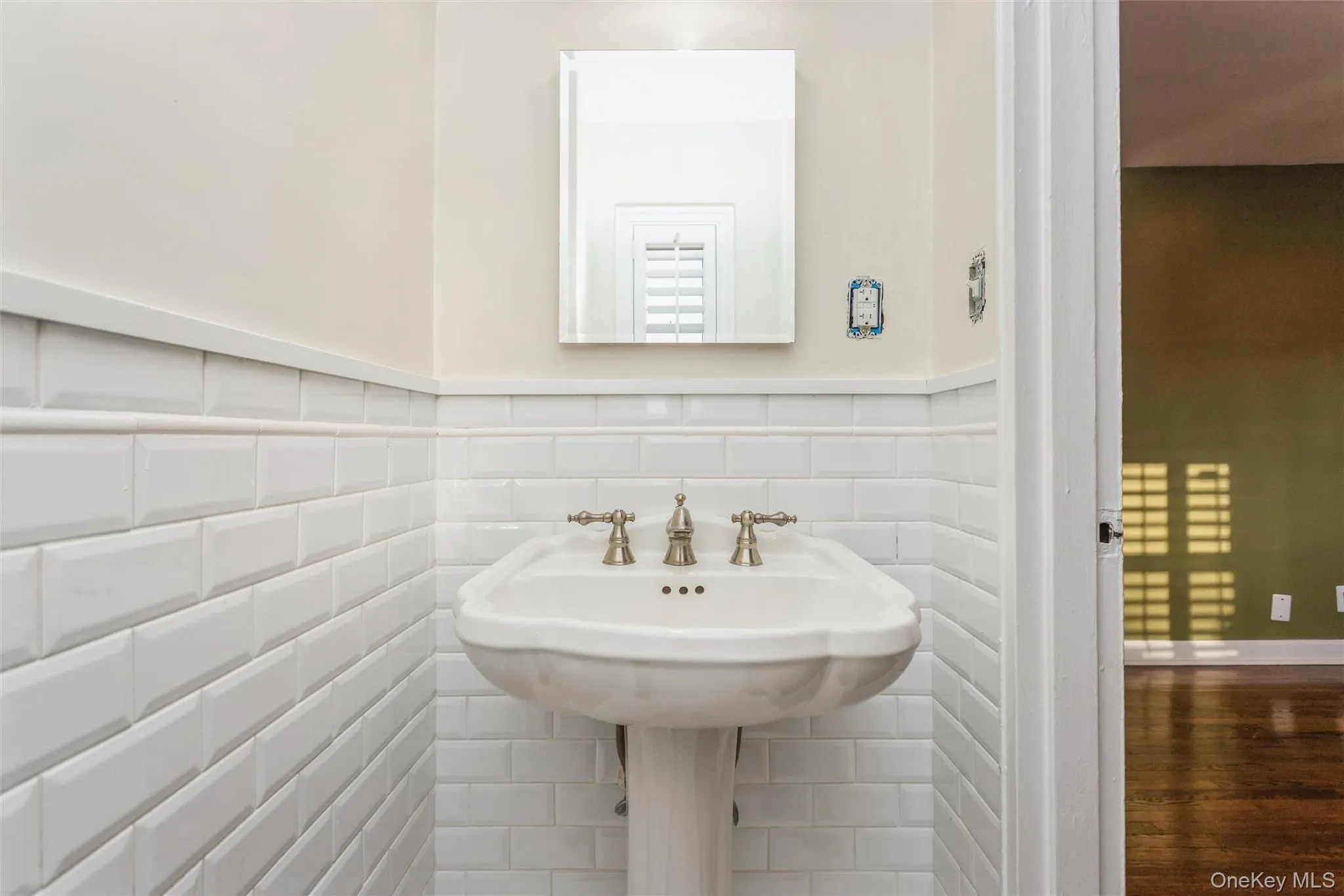 Half bath with a wainscoted wall, wood finished floors, and tile walls Half bath with a wainscoted wall, wood finished floors, and tile walls