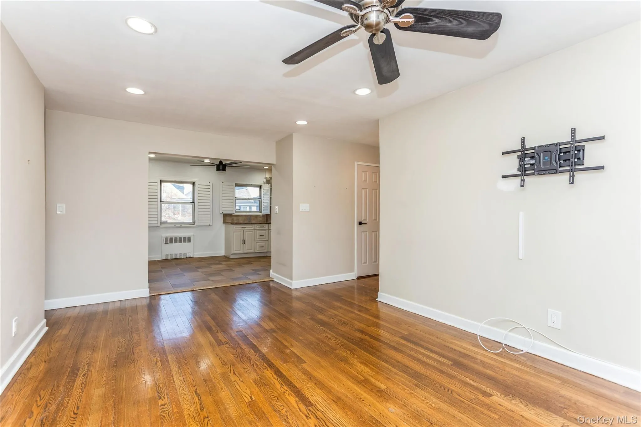 Unfurnished living room featuring hardwood / wood-style floors, recessed lighting, radiator heating unit, and a ceiling fan Unfurnished living room featuring hardwood / wood-style floors, recessed lighting, radiator heating unit, and a ceiling fan