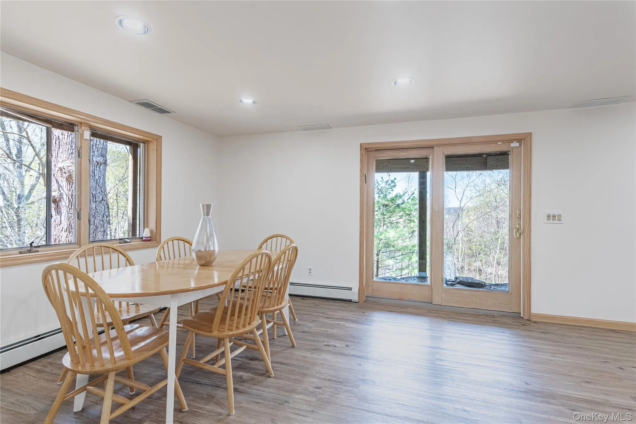 Dining room featuring healthy amount of natural light, light wood finished floors, recessed lighting, and a baseboard heating unit Dining room featuring healthy amount of natural light, light wood finished floors, recessed lighting, and a baseboard heating unit
