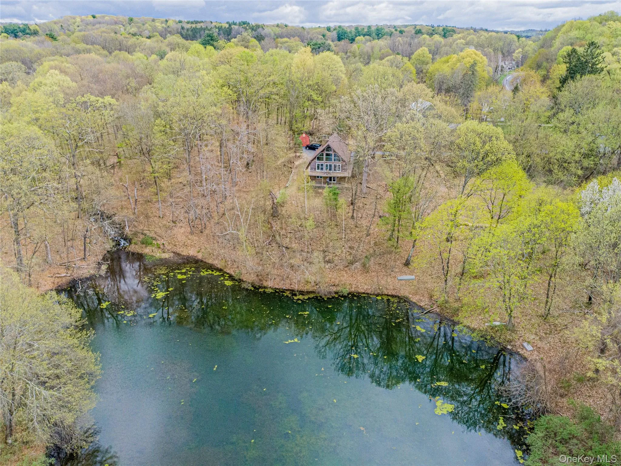 Bird's eye view of a heavily wooded area and a large body of water Bird's eye view of a heavily wooded area and a large body of water