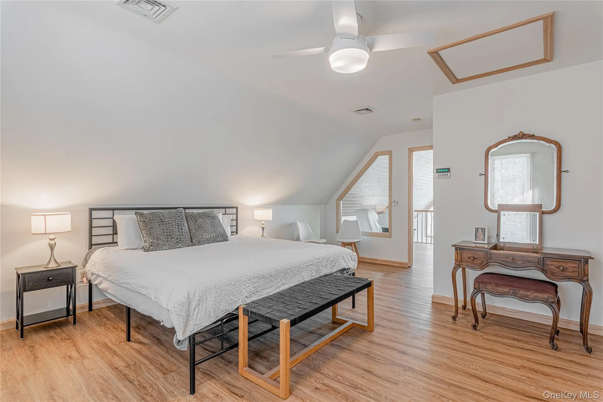 Bedroom with attic access, light wood-style floors, a ceiling fan, and lofted ceiling Bedroom with attic access, light wood-style floors, a ceiling fan, and lofted ceiling