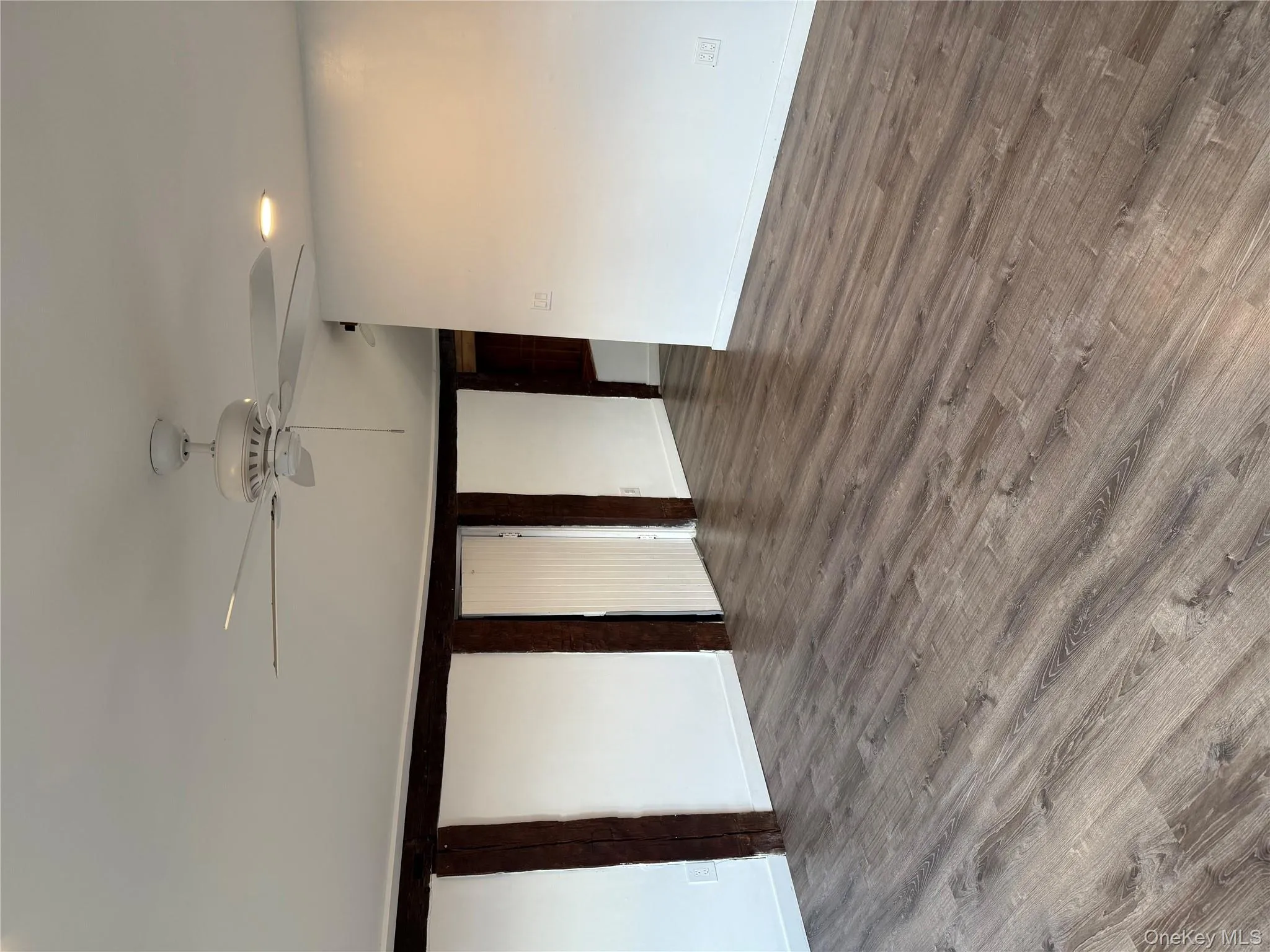 Spare room with wood finished floors and a ceiling fan Spare room with wood finished floors and a ceiling fan