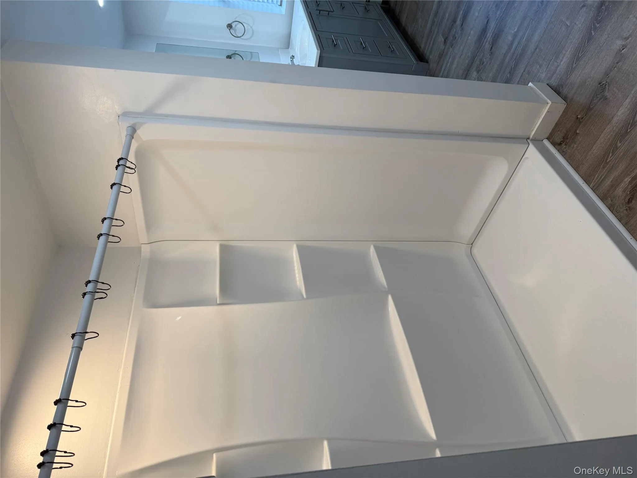 Bathroom with dark wood-type flooring, vanity, and a stall shower Bathroom with dark wood-type flooring, vanity, and a stall shower