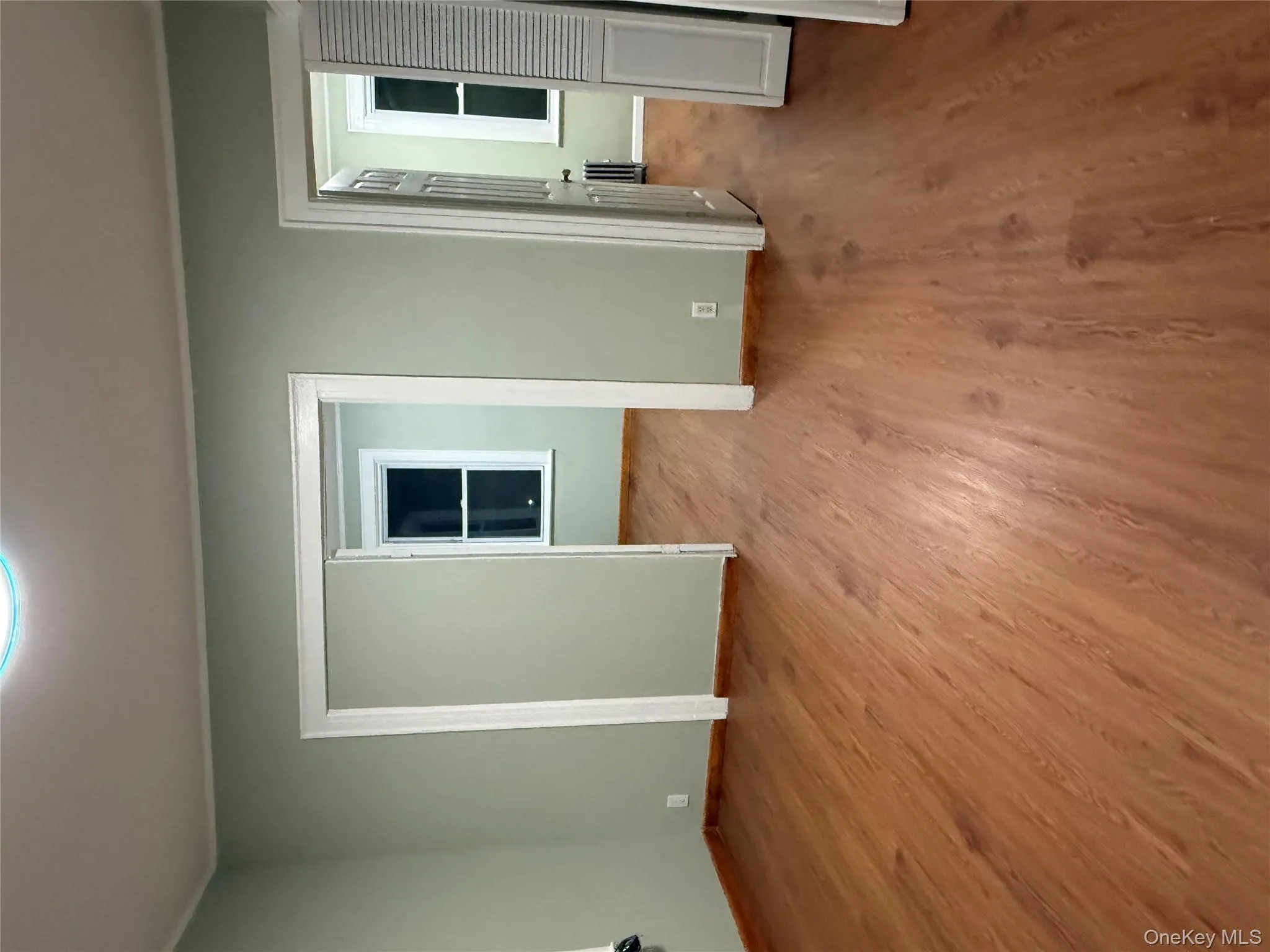 Living room featuring wood finished floors, radiator, and crown molding Living room featuring wood finished floors, radiator, and crown molding
